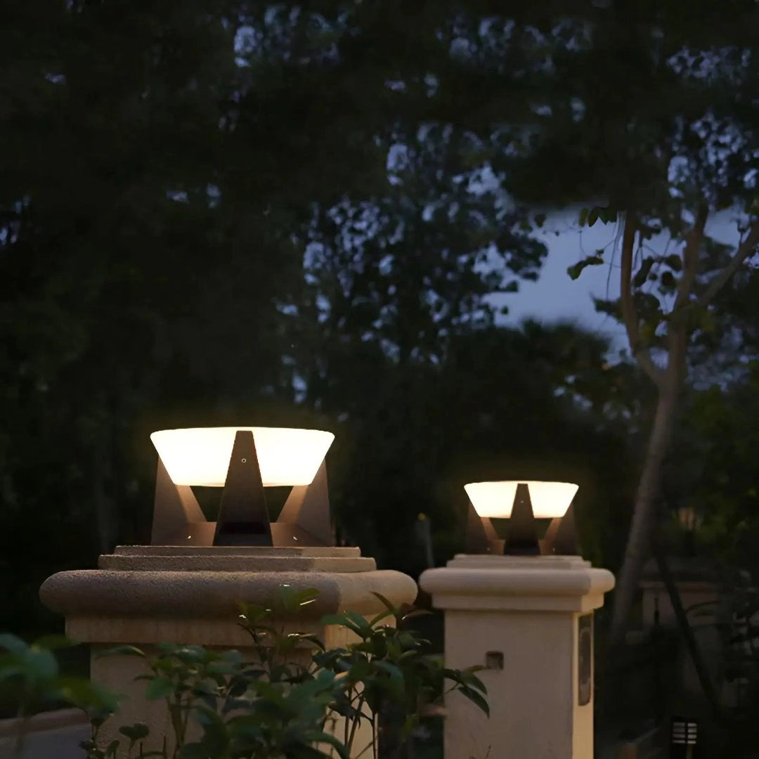 Modern SolarLux outdoor lighting torches illuminating a garden area surrounded by plants and trees, with a wooden table and lanterns casting warm, ambient light in the darkness.