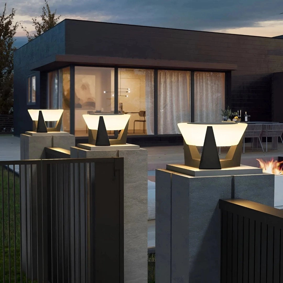 Modern solar-powered outdoor torch lights illuminating a garden area with a clear sky and surrounding plants, enhancing the exterior design of a building with a stylish and contemporary look.