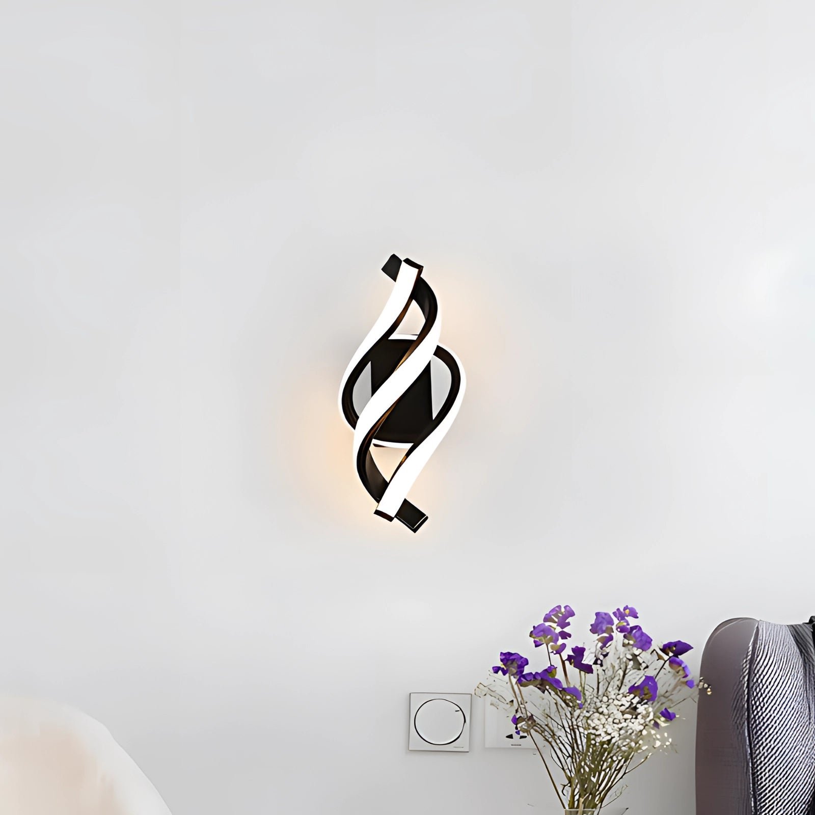 Modern black spiral LED wall sconce mounted on a wall, showcasing minimalist and energy-efficient design.