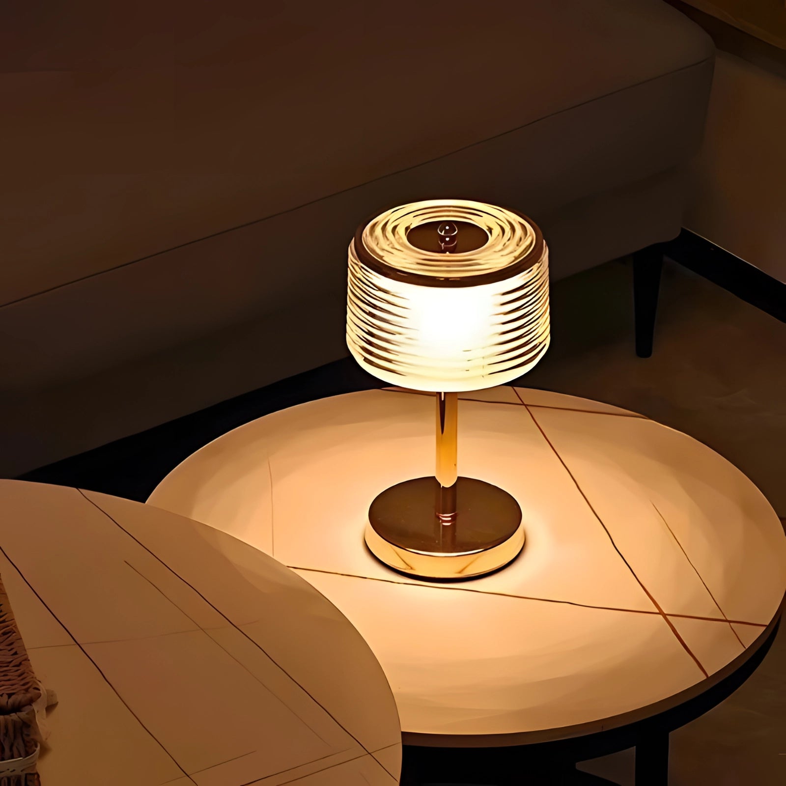 Modern spiral shade table lamp with a warm glow, featuring a metallic base. The lamp's spiral design creates an artistic and contemporary look, adding a touch of elegance to any room.