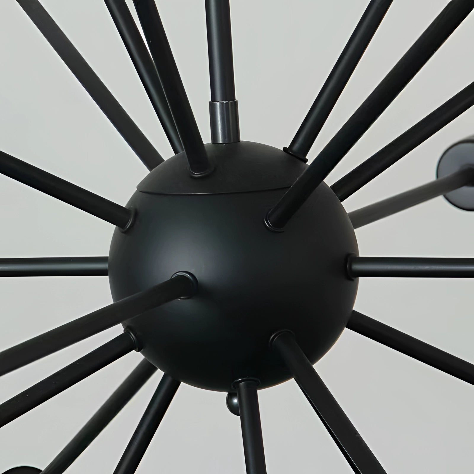 A modern Sputnik chandelier featuring a 12-light black pendant design with Edison-style bulbs, showcasing a radial arrangement of arms and bulbs reminiscent of a classic wheel or spoke pattern.