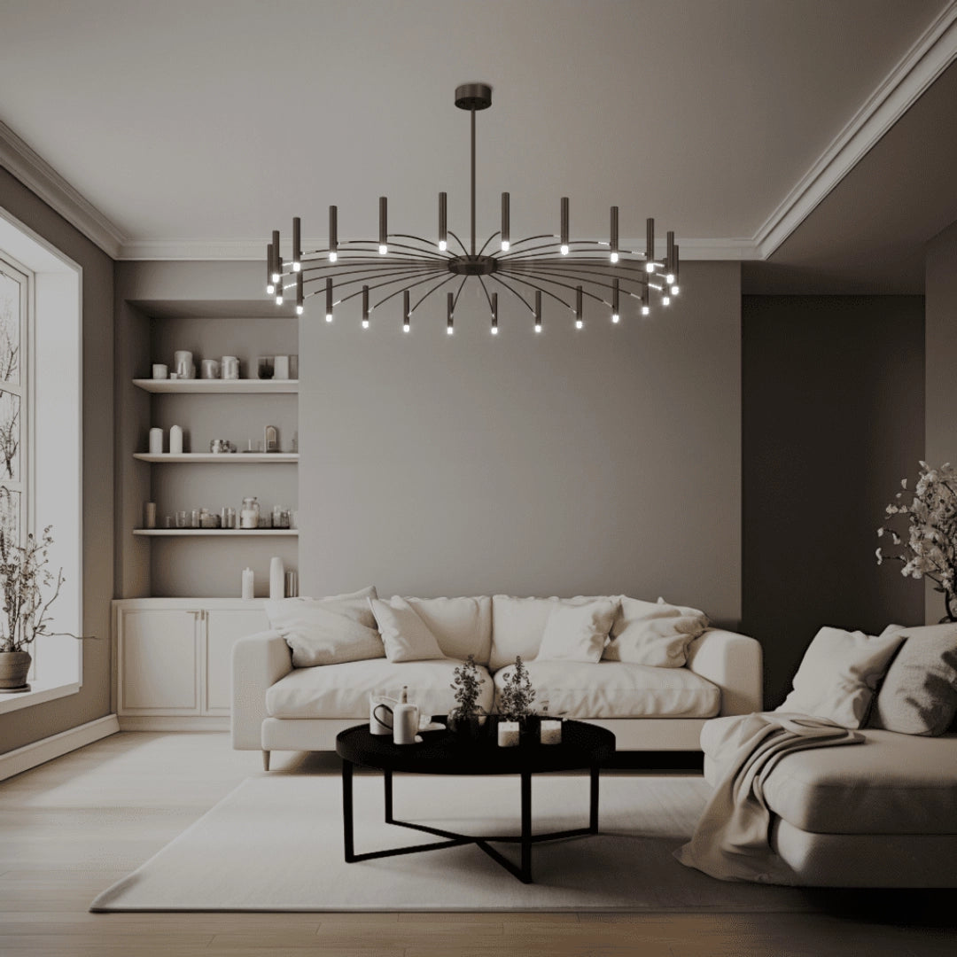 Modern starburst chandelier with a sleek design illuminating a minimalist interior featuring a white couch, picture frames, and wooden elements.