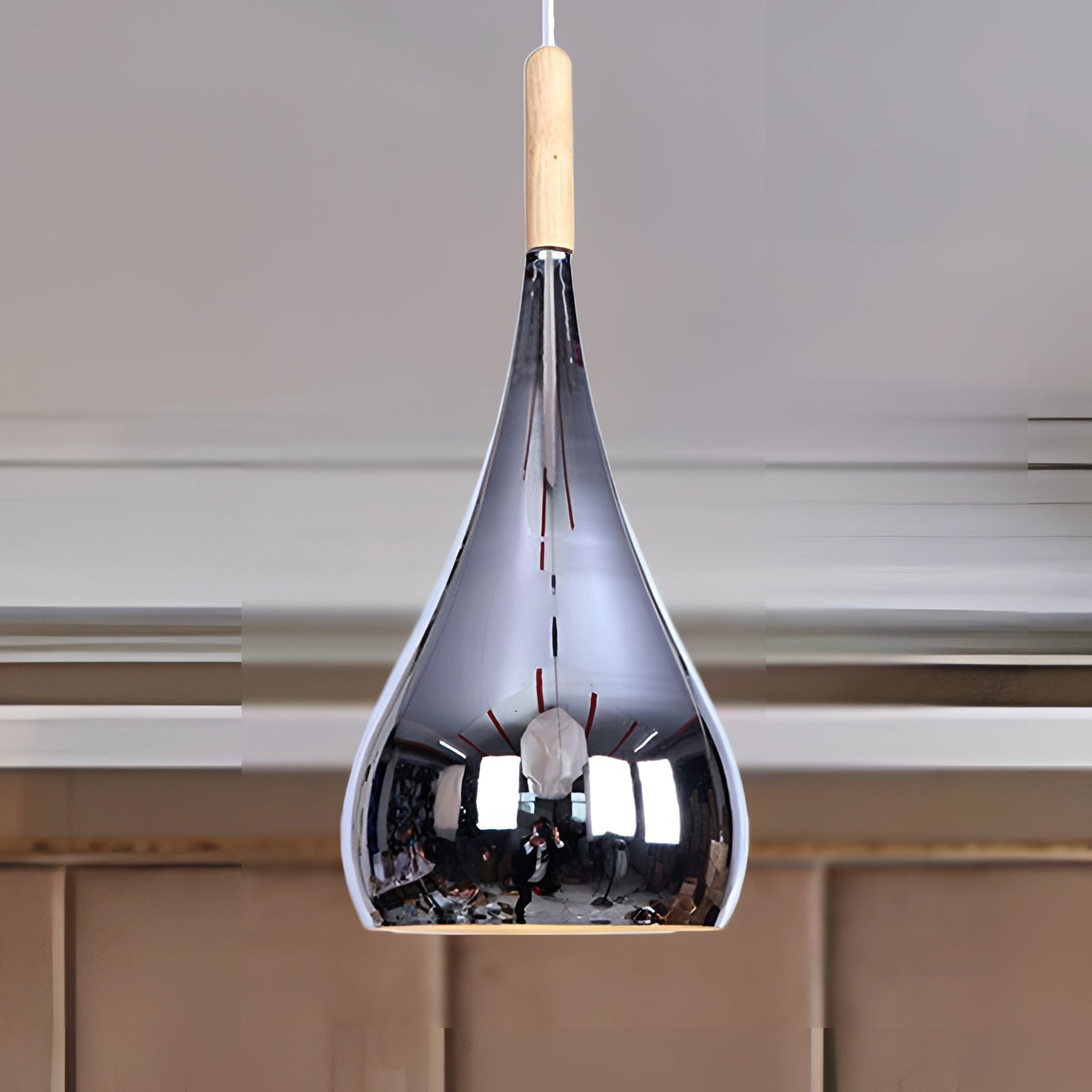 Modern teardrop smoked glass pendant light hanging from a wooden ceiling fixture in a contemporary kitchen setting.