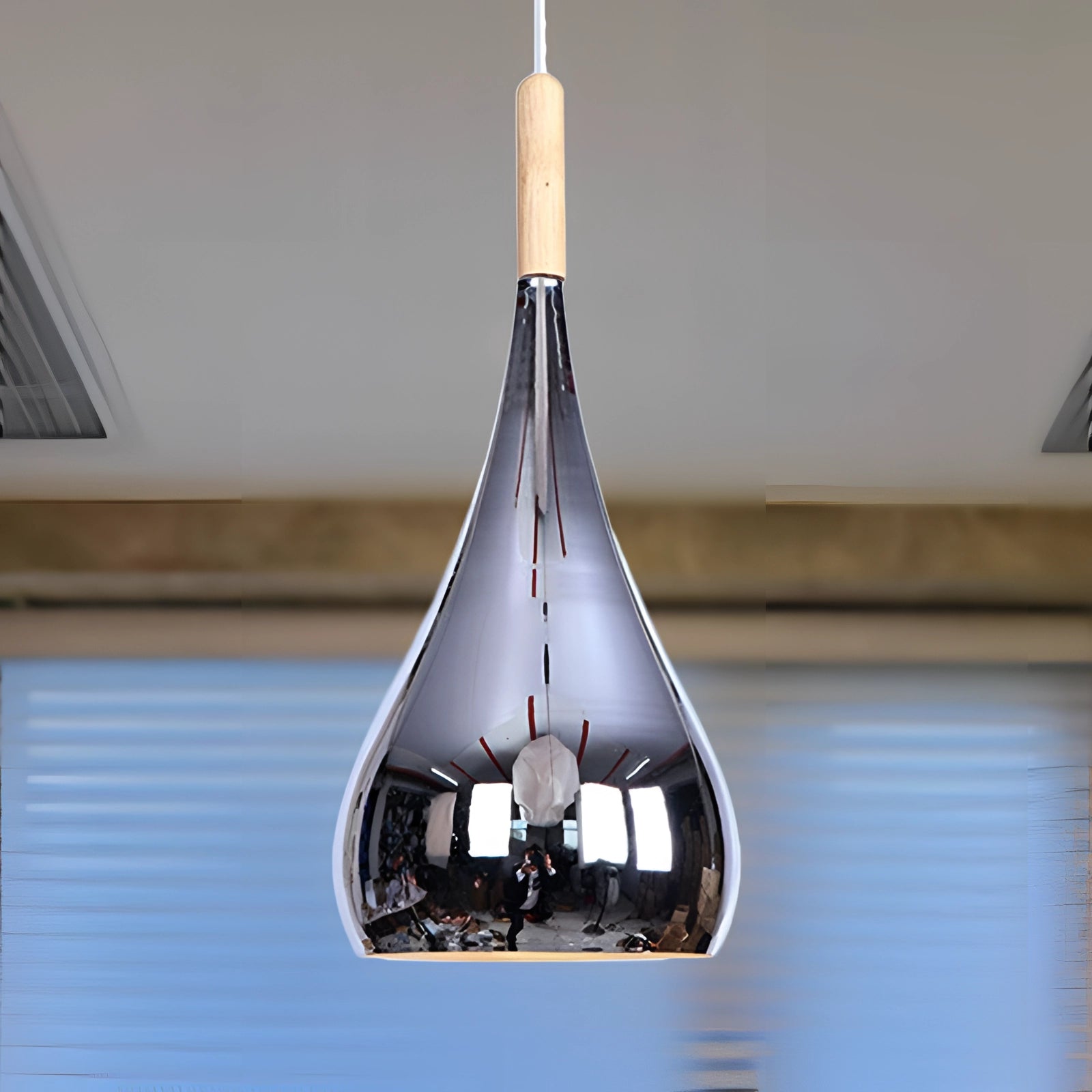 A modern teardrop-shaped pendant light made of smoked glass, designed for contemporary kitchens, featuring a sleek and elegant aesthetic with a wood accent.