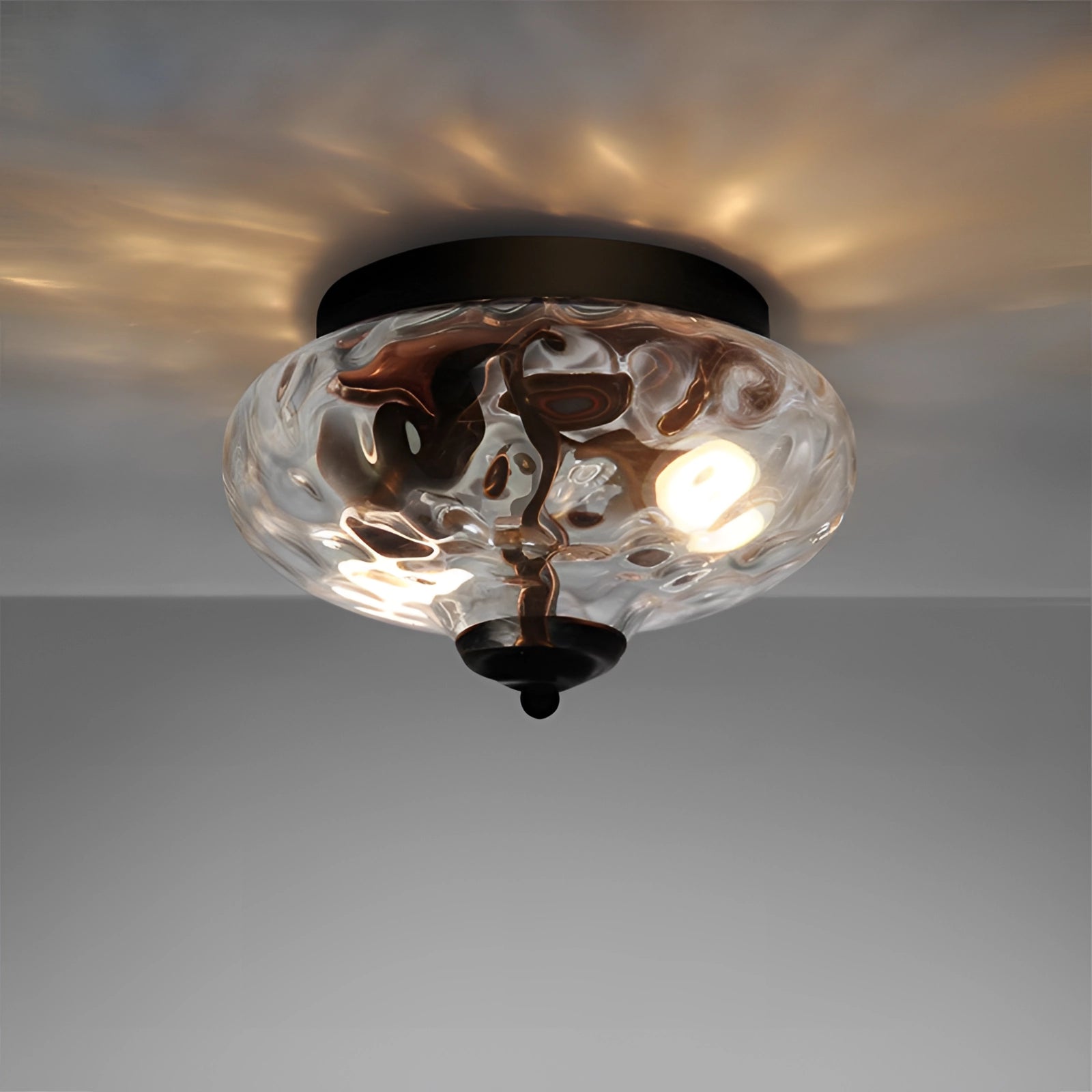 Modern textured glass ceiling light fixture with a swirl pattern design, featuring a circular shape, hanging against a backdrop resembling sky and clouds.