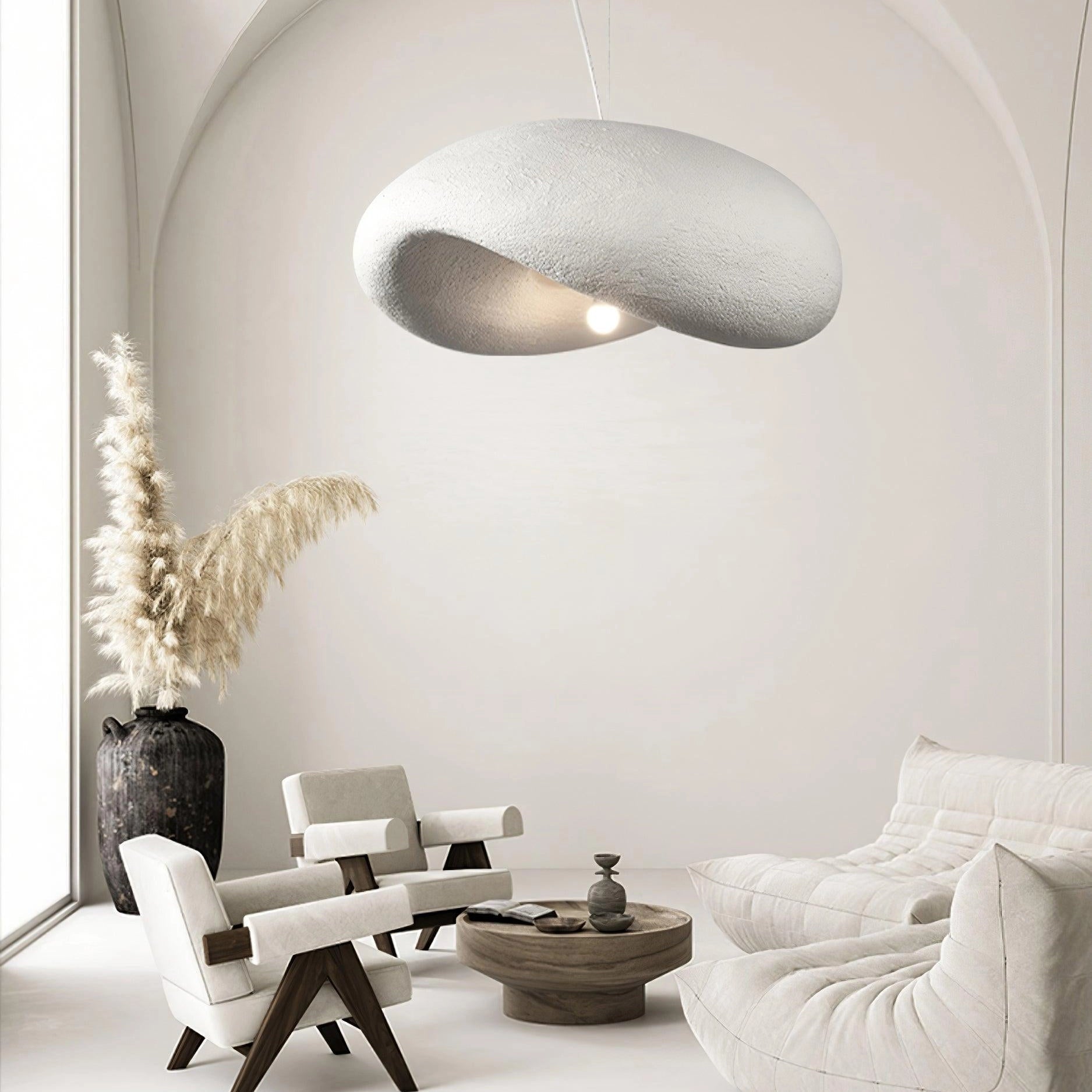 Modern textured pendant light with minimalist pebble design, featuring a stone finish, displayed in an interior setting.
