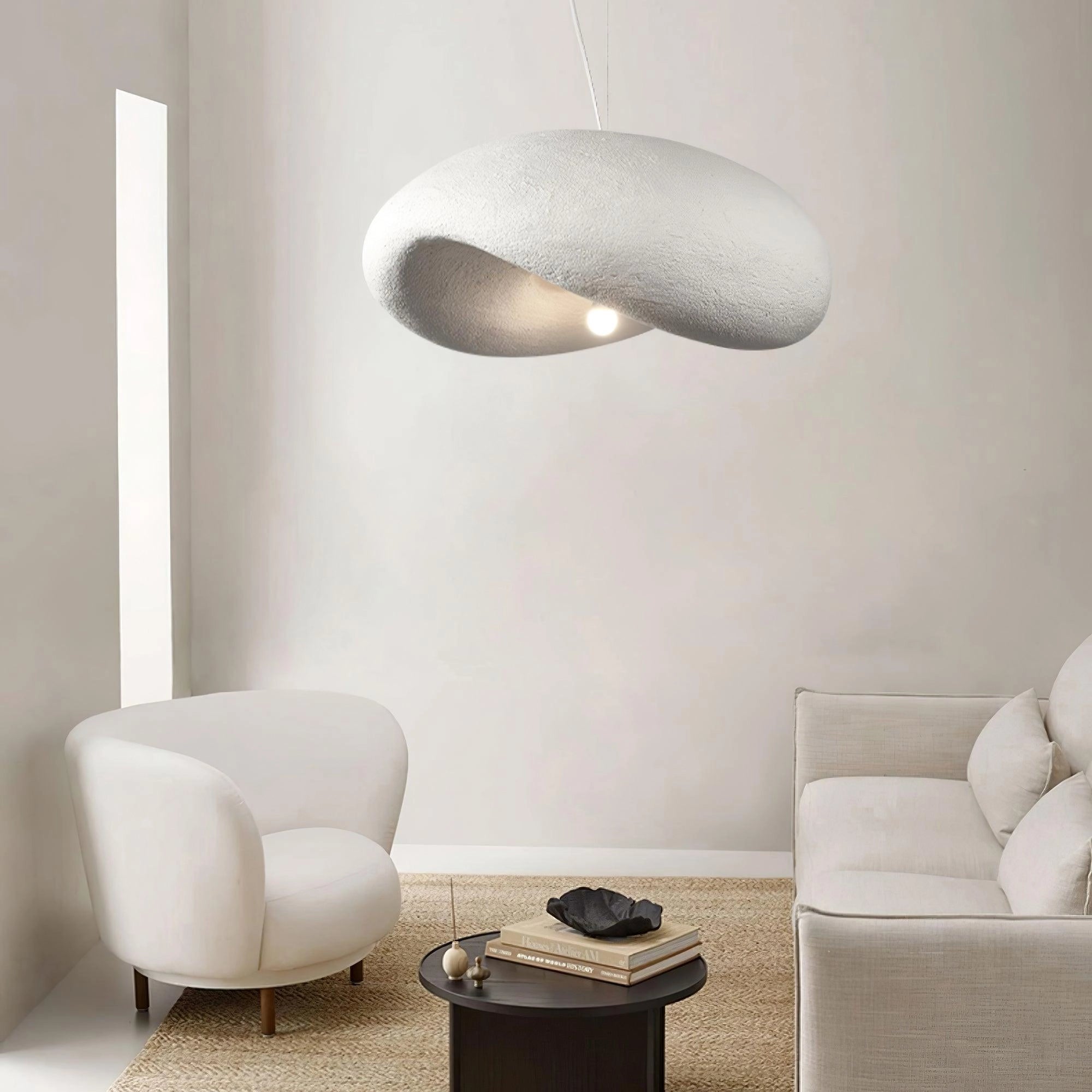 Modern textured pendant light with a minimalist pebble design and stone finish, measuring 31.5 inches, hanging in a stylishly furnished living room interior.