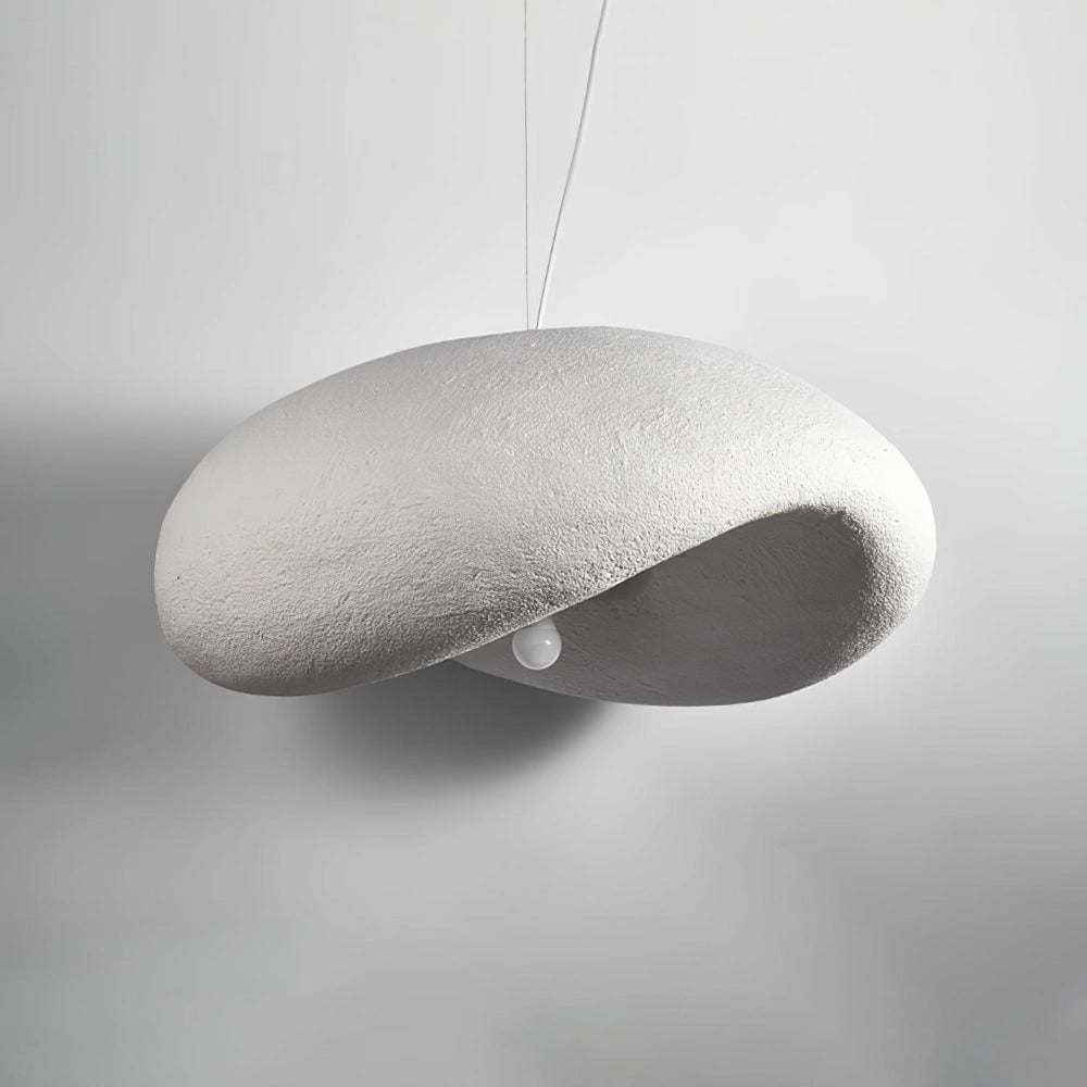 Modern textured pendant light with a minimalist pebble design in a stone finish, hanging from the ceiling with a sleek metal construction, set against a dark monochrome background.