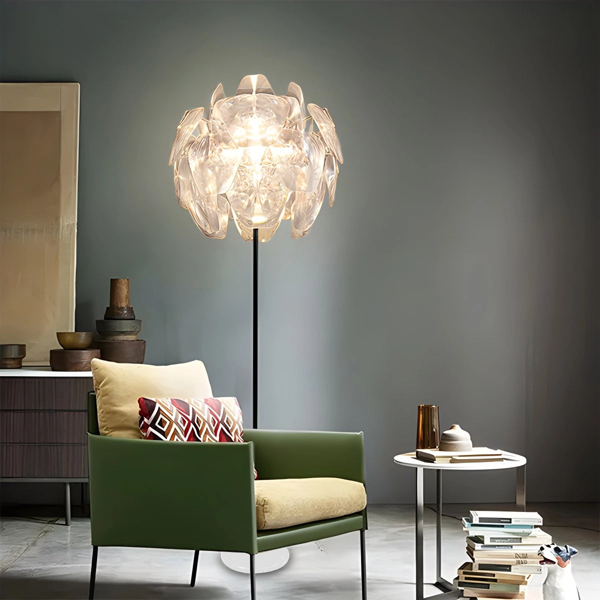 Modern tri-leg floor lamp with a petal design and clear acrylic globe, positioned in a stylish living room with white furniture and cozy textiles.