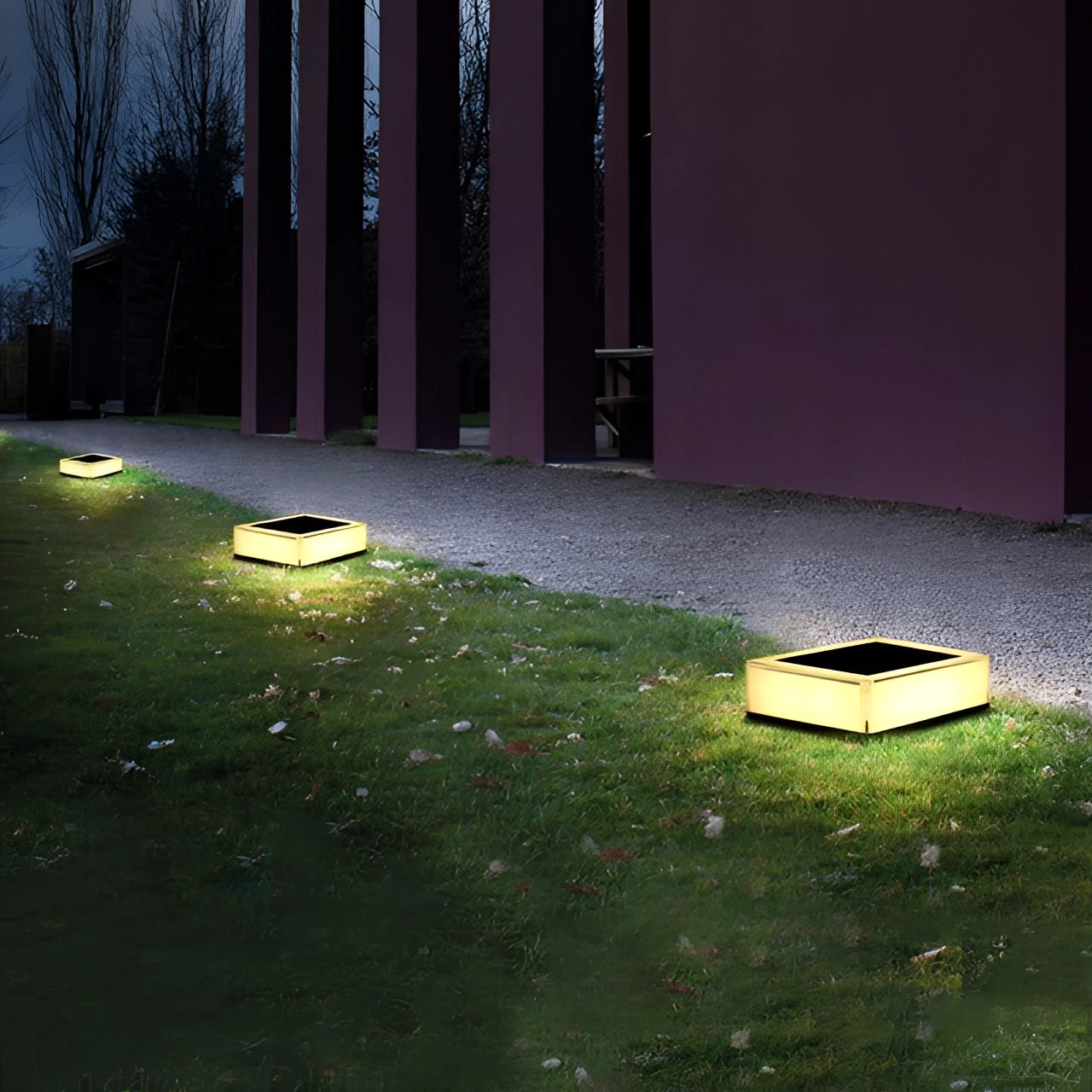 Modern waterproof LED cube seat with ambient lighting, placed outdoors on a wooden deck surrounded by grass and plants.