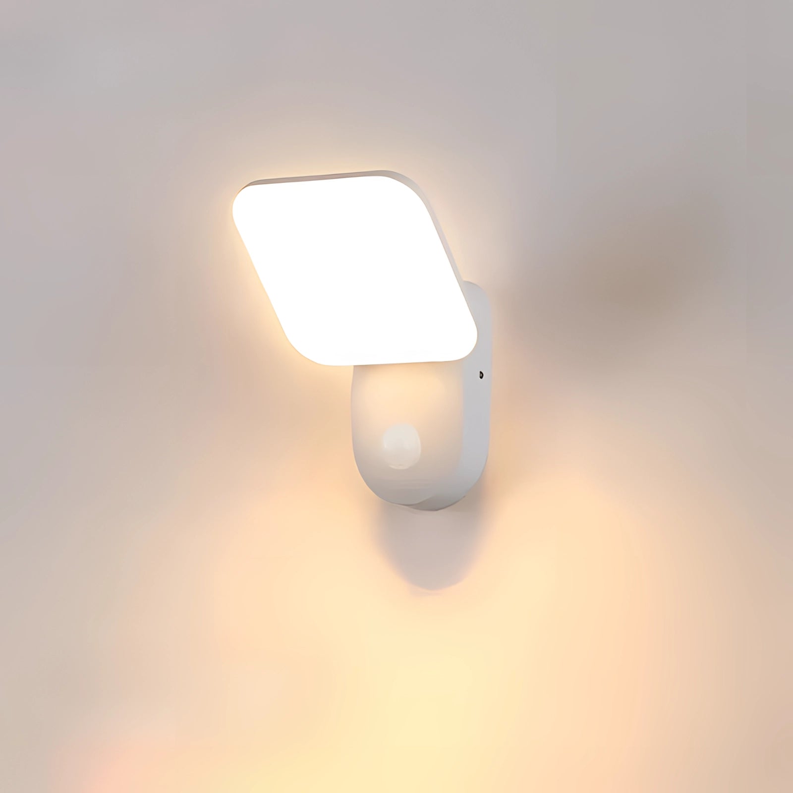 Modern white square LED wall lantern with motion sensor, featuring a cool white light, mounted on a wooden wall. The design resembles a contemporary street light, blending rectangular and circular elements for a sleek appearance.