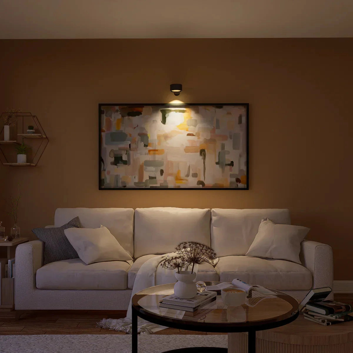 Modern white adjustable LED wall spotlight illuminating a minimalist living room with a wooden table, comfortable couch, and picture frames.