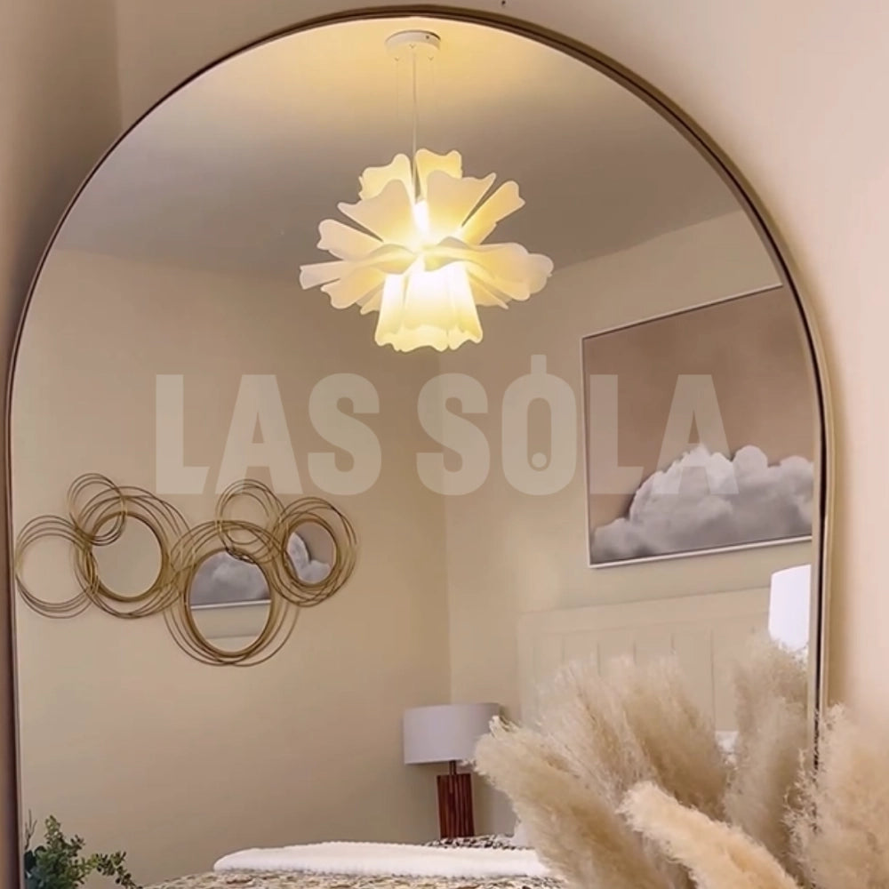 Modern white floral pendant light with a decorative blossom design, hanging from the ceiling in a stylish interior setting, enhancing the room's lighting and aesthetic appeal.