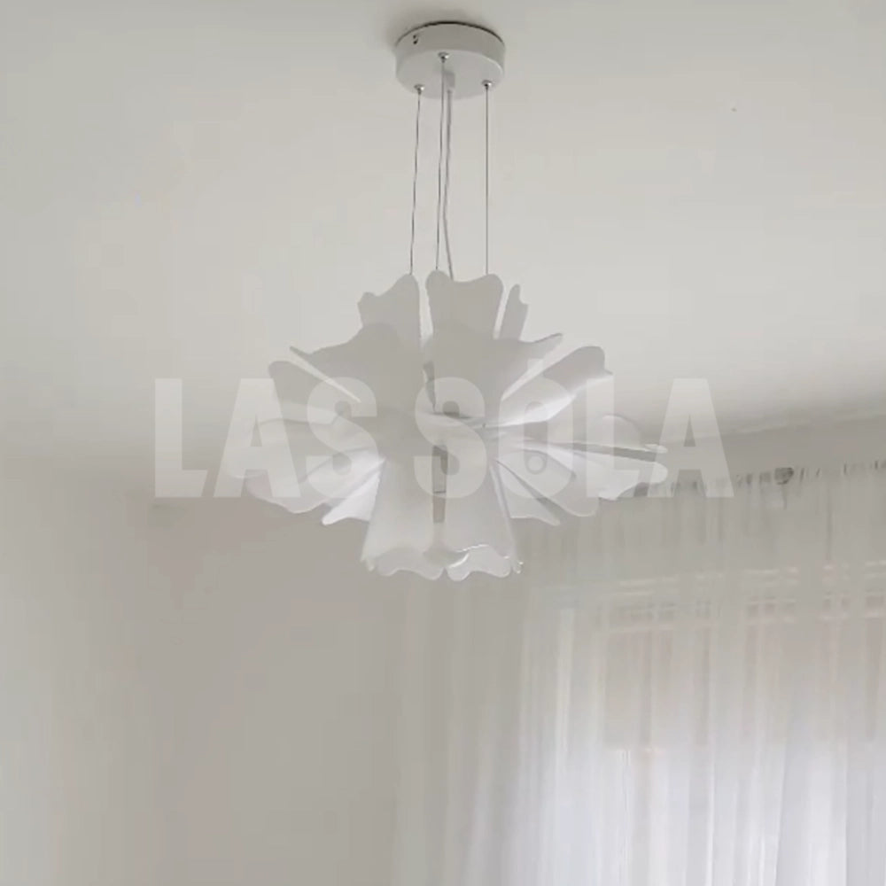 Modern white floral pendant light with decorative blossom design, featuring petal-like patterns and circular elements, hanging from the ceiling as a stylish fixture.
