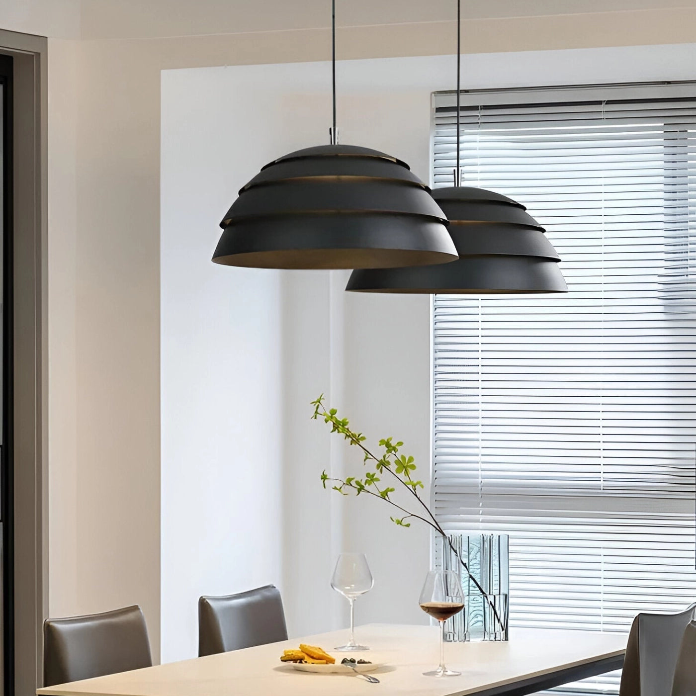 Modern white layered pendant light hanging from the ceiling, illuminating a minimalist interior with wooden accents and furniture.