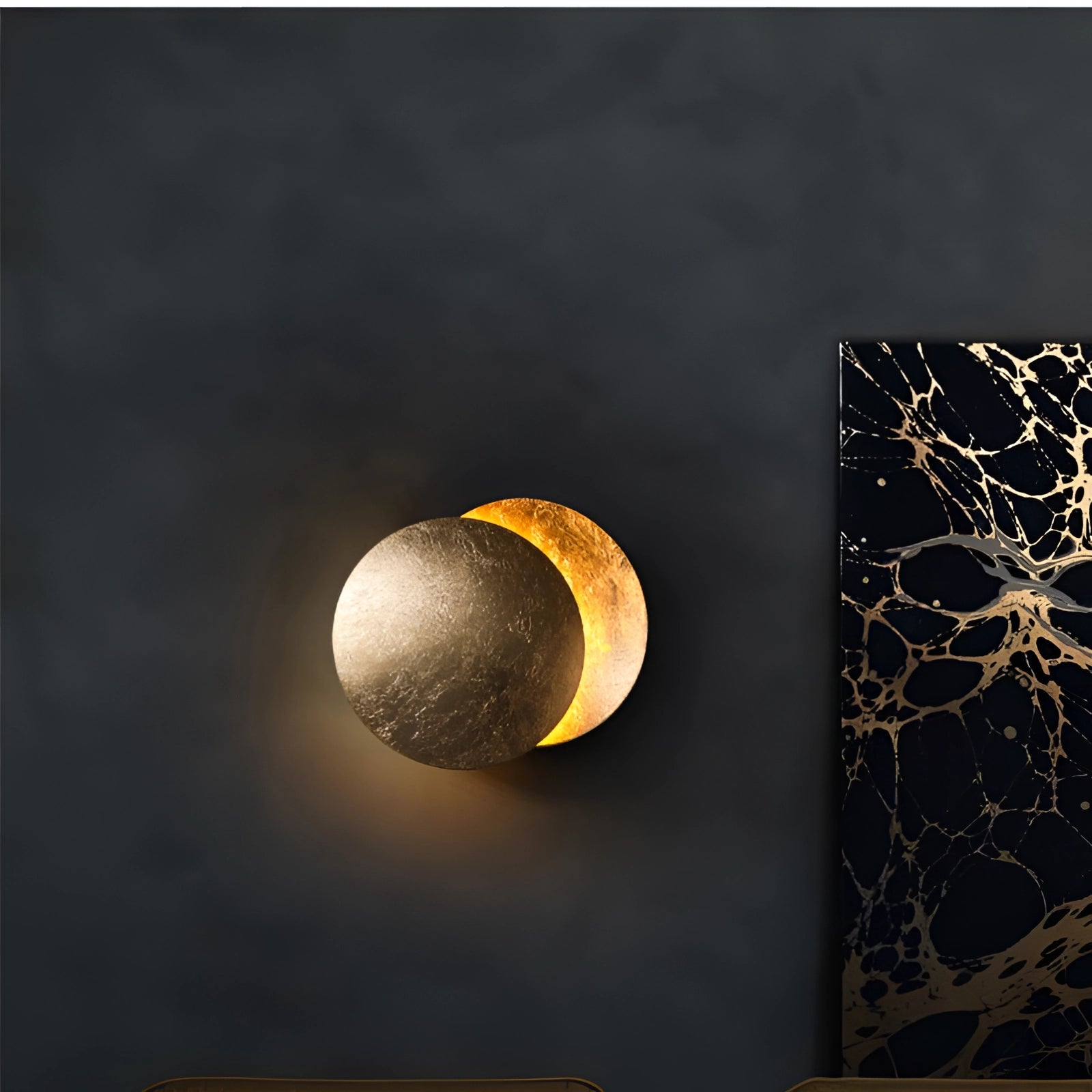 Luxury gold moon-phase wall light in a circular design, resembling a full moon against a dark background, ideal for adding an artistic touch to space-themed decor.