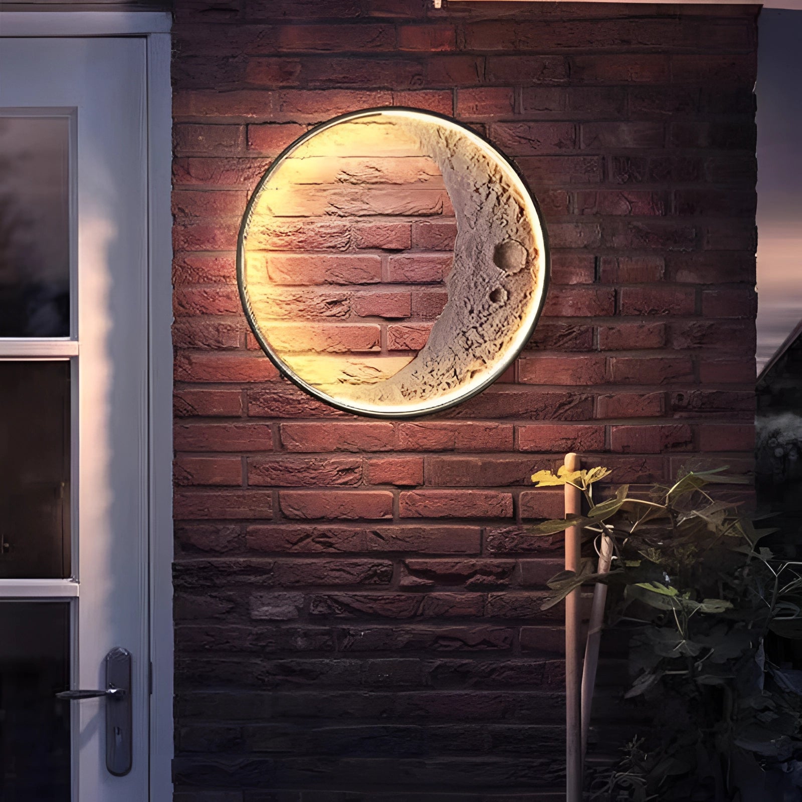 Moon Phase Wall Lights in 60cm size featuring celestial crescent and lunar ambient lighting, mounted on a wooden rectangular frame against a brick wall background, with plants nearby.