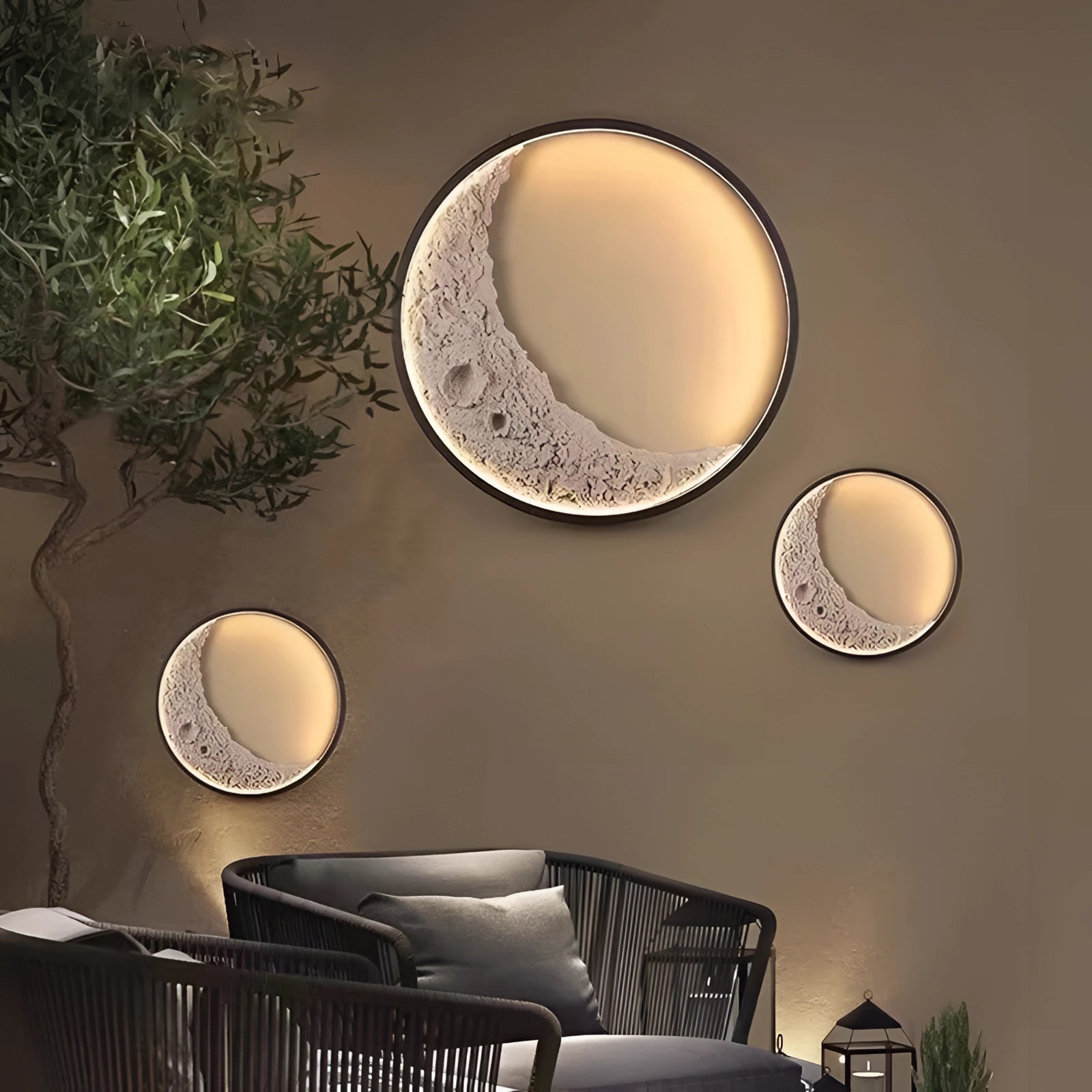 Moon Phase Wall Lights illuminating a cozy room with a coffee cup and plant on a wooden table in the foreground.