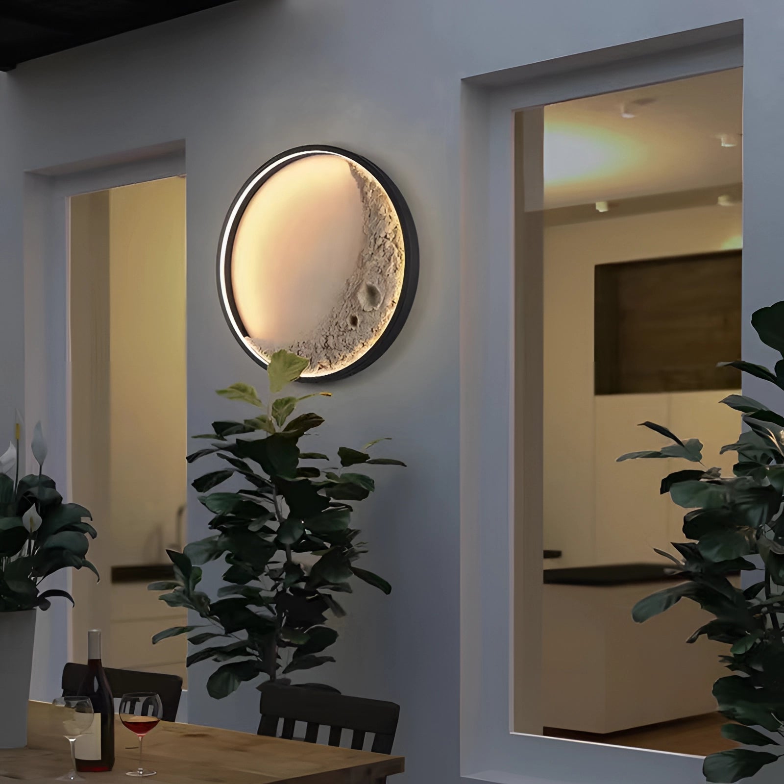 Moon phase wall lights featuring celestial crescent and lunar ambient lighting, displayed in a cozy interior with houseplants, a wooden table, and a makeup mirror.