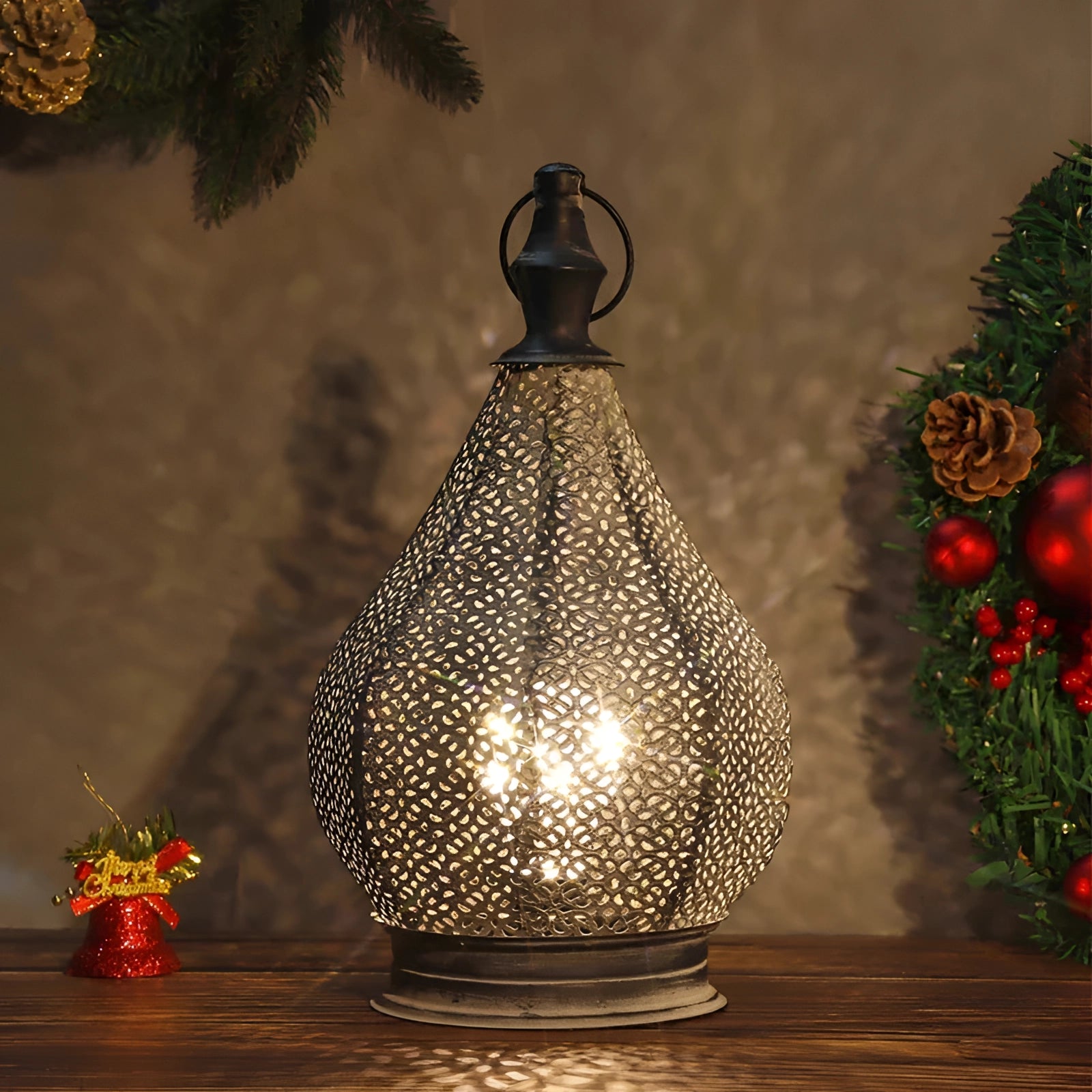 Handcrafted Moroccan metal table lamp with intricate ethnic patterns, set against a cozy interior design background, featuring holiday ornaments and an evergreen plant.