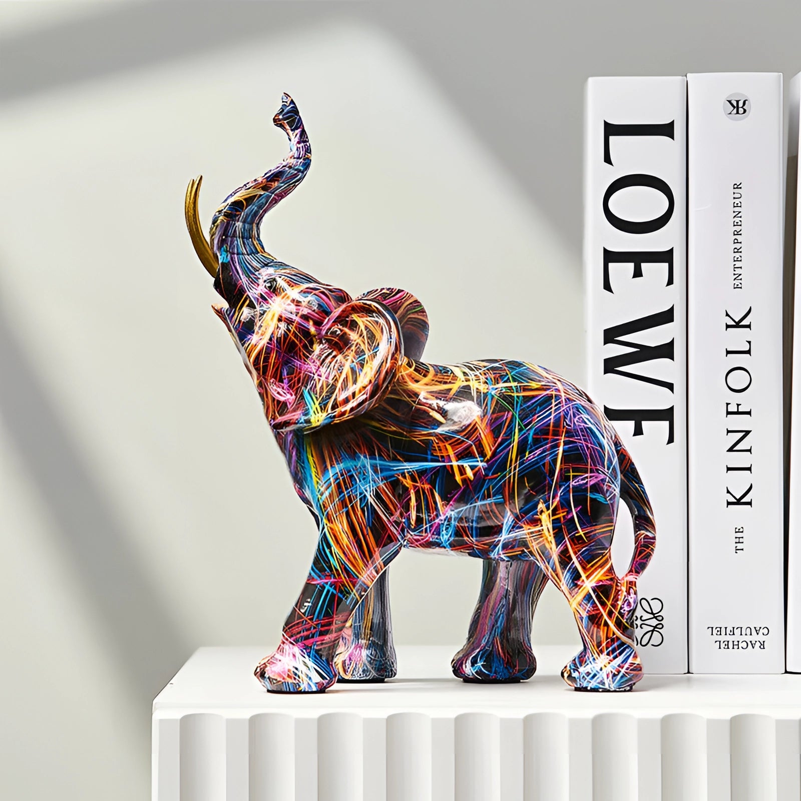 Multicolored neon abstract elephant sculpture featuring a vibrant and creative design, ideal for adding a pop of color to home decor. The sculpture showcases intricate patterns and artistic elements, highlighting the elephant's form and snout.