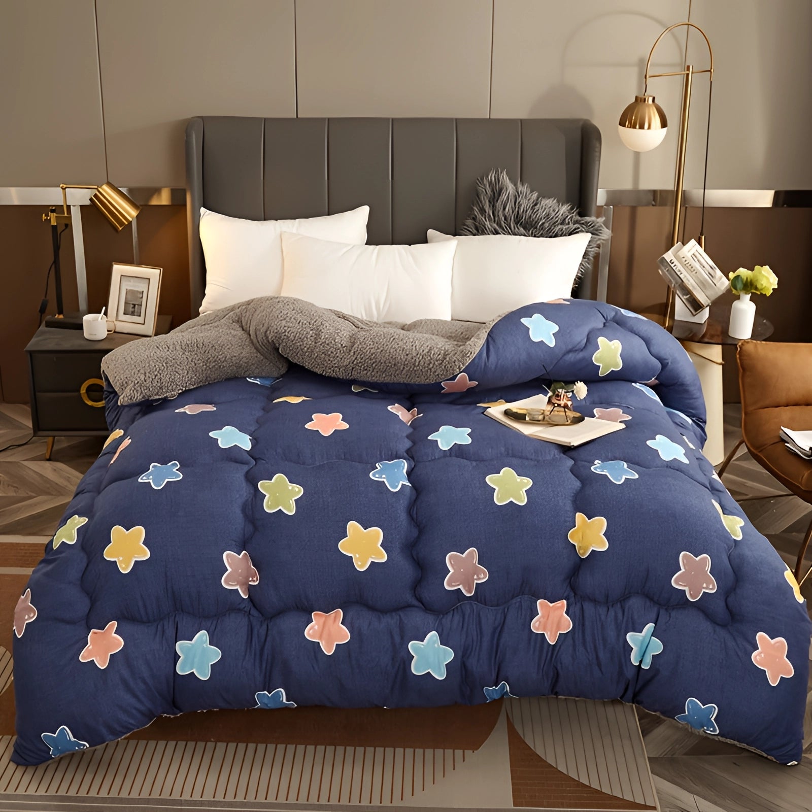 Navy blue star pattern comforter on a bed with a wooden frame, accompanied by pillows, a lamp, and a potted plant, set against grey flooring in a stylish bedroom setting.