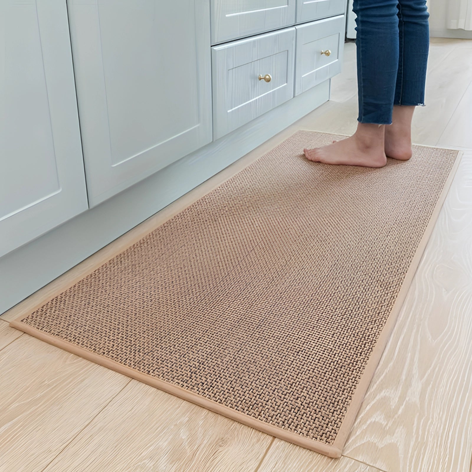 Beige rectangular non-slip kitchen mat placed on a wooden floor in front of cabinetry, measuring 50 x 120 cm, made of durable sisal material.