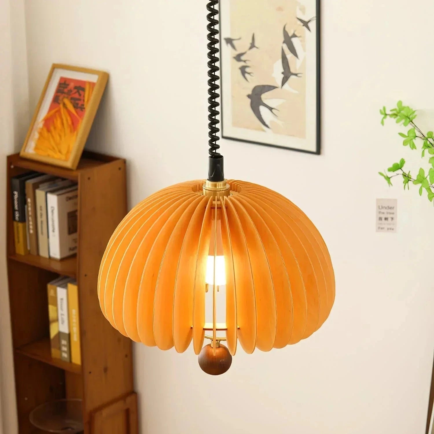 Orange Scandinavian ribbed pendant light hanging in a modern kitchen interior, featuring a warm amber glow. The stylish lamp complements the contemporary design, with wooden accents and a minimalist aesthetic.