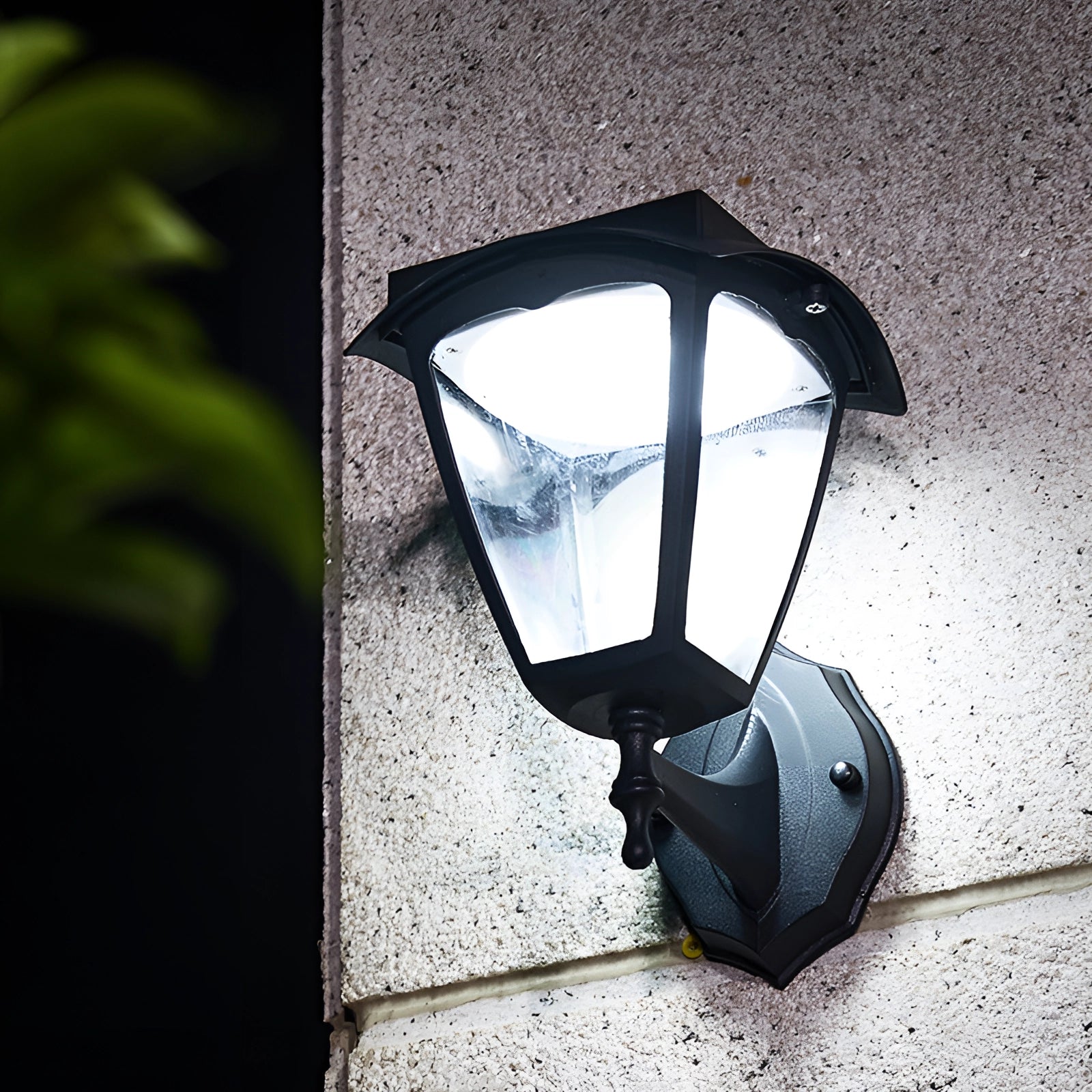 Outdoor LED wall lantern with energy-efficient lighting, water-resistant black finish, mounted on an exterior wall at night.