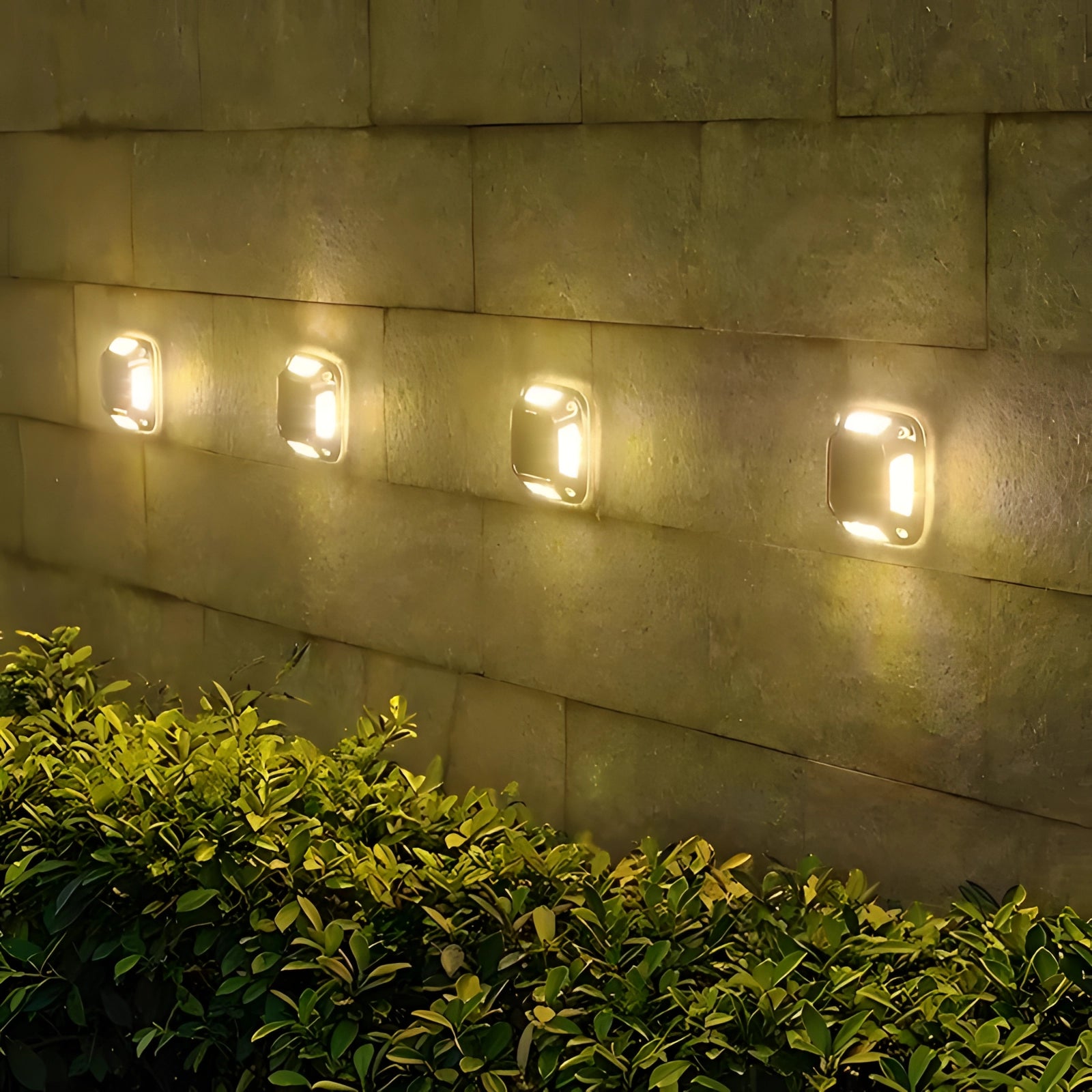 Outdoor solar path lights with LED bulbs emitting warm white light, set of 8 pieces, illuminating a garden path surrounded by grass and plants in low light conditions. The lights have a rectangular design, casting an amber hue that enhances the natural setting.