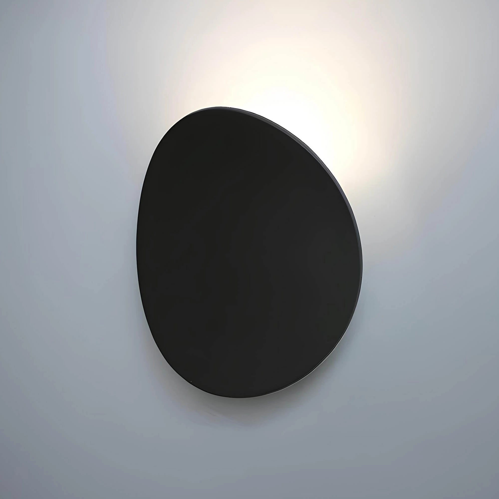 Oval wall mirror with a sleek black frame, designed for a minimalist modern decor, reflecting a contemporary aesthetic.