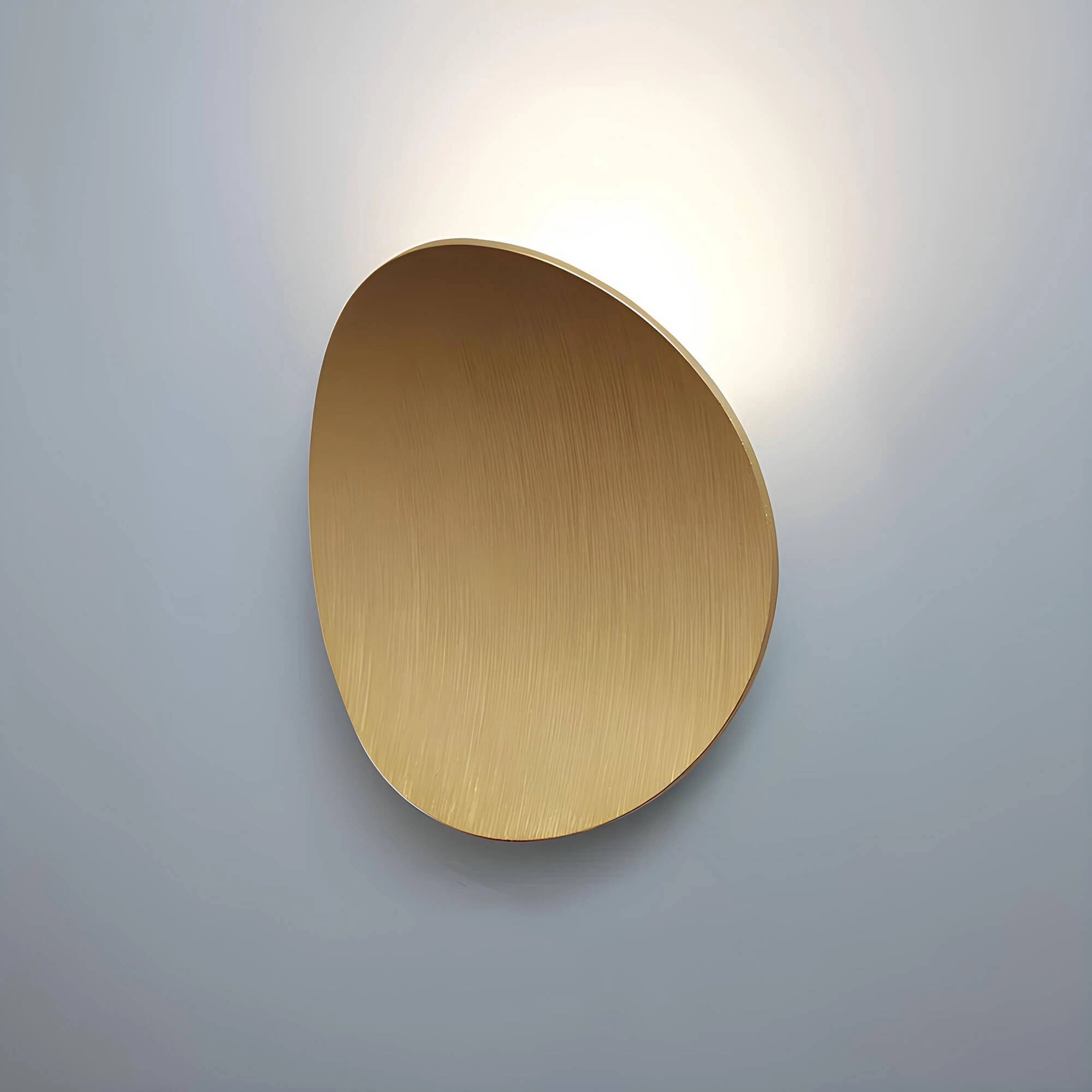 Oval wall mirror with a sleek gold frame, reflecting minimalist modern decor in a contemporary setting.
