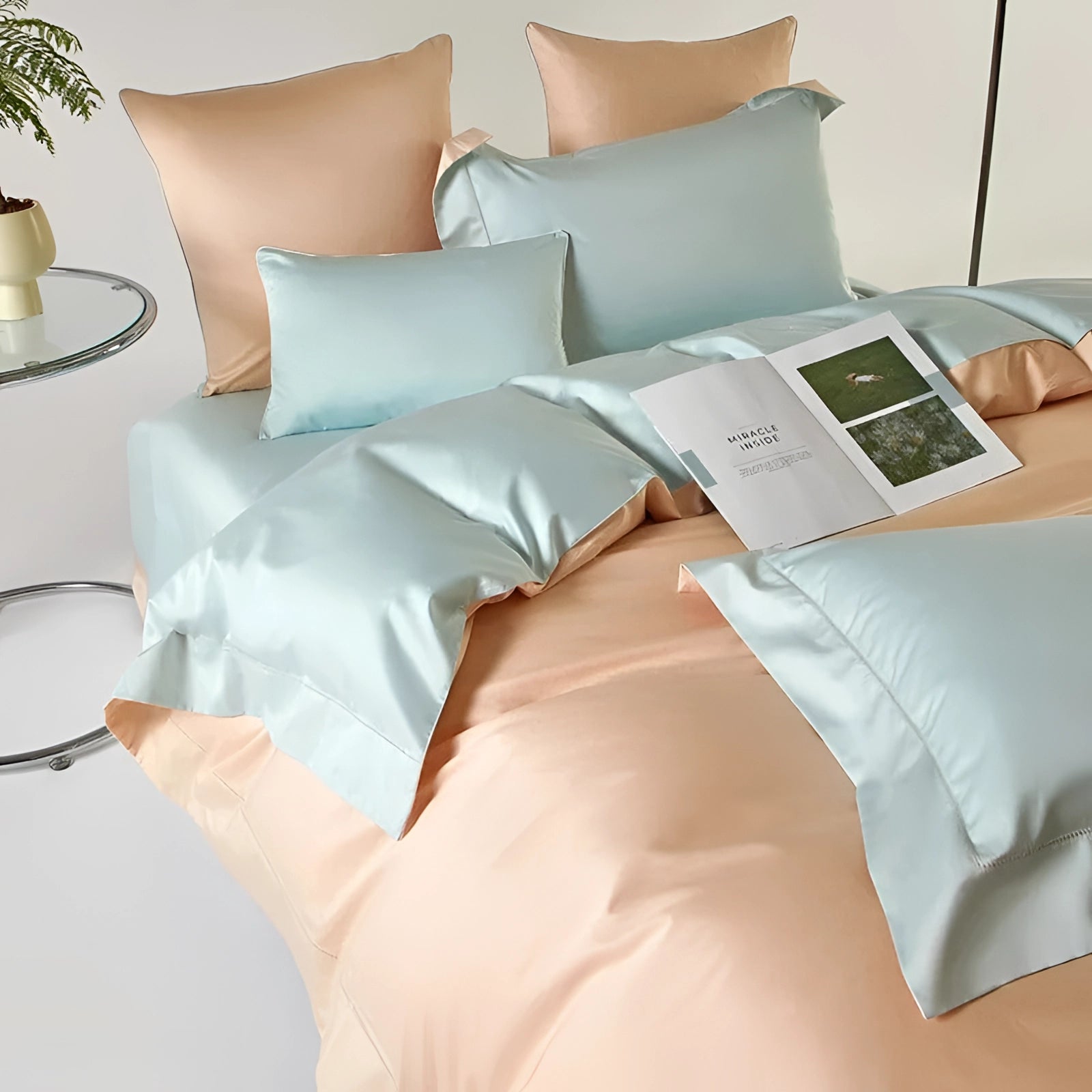 Pastel reversible satin duvet set in peach and aqua on a neatly made bed, featuring a comfortable American King size. The bedding set includes matching pillows and adds a touch of elegance to the bedroom with its soft, lightweight texture.
