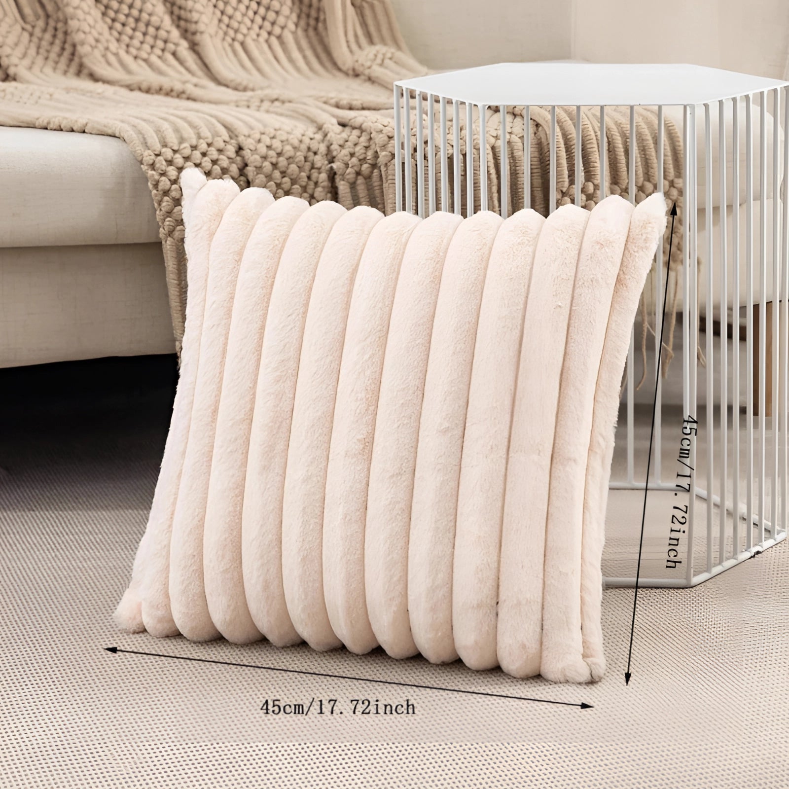 Soft pink corduroy pillow with a ribbed texture, displayed on a hardwood floor next to outdoor furniture and a studio couch.