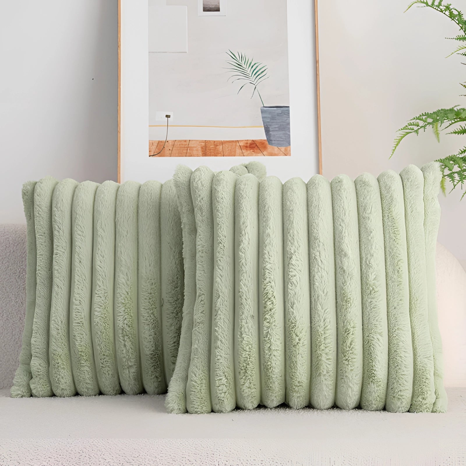 Pink corduroy pillow with a soft ribbed texture placed on a studio couch in a living room setting, surrounded by a wooden table and indoor plants, showcasing a cozy and stylish interior design.