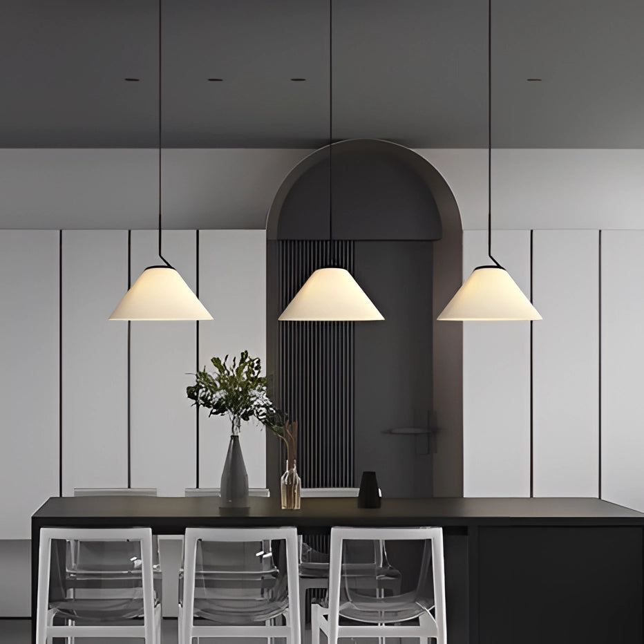 White pleated pendant light with adjustable height, featuring a Scandinavian design, hanging above a table with a plant nearby, creating a stylish and modern interior setting.