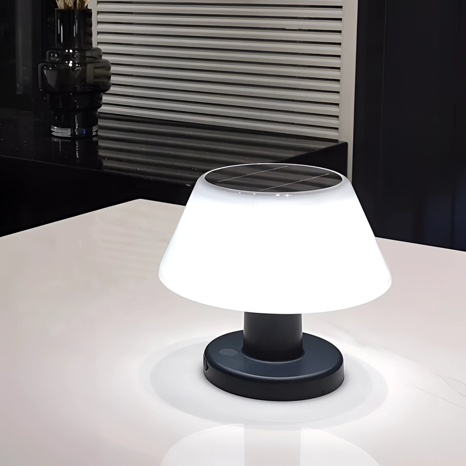 Rechargeable cordless LED table lamp with adjustable brightness, featuring a modern design and blue base, placed on a white table.
