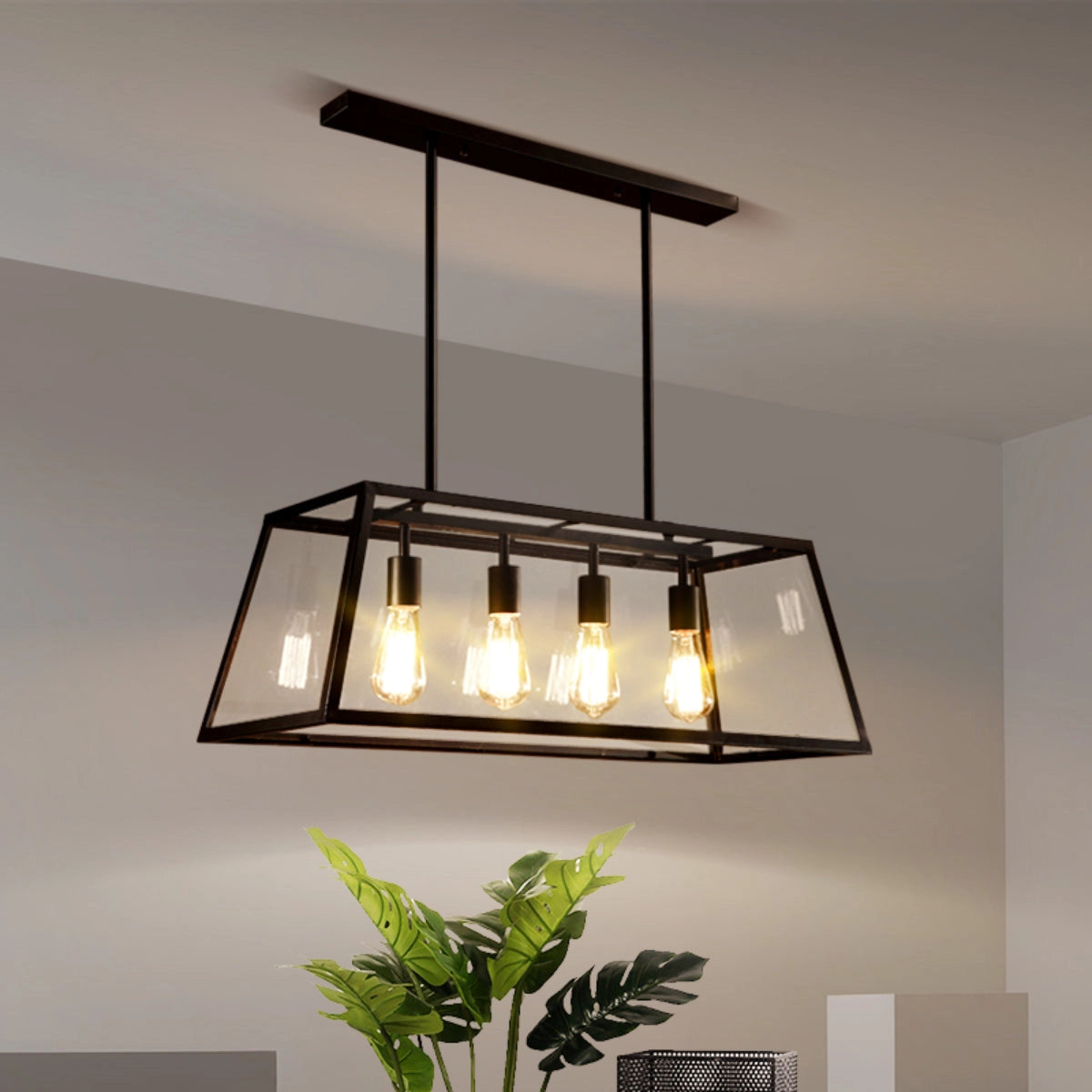 Rectangular industrial chandelier made of black metal with clear glass panels, featuring a sleek and modern design, hanging above a wooden table with decorative plants nearby.