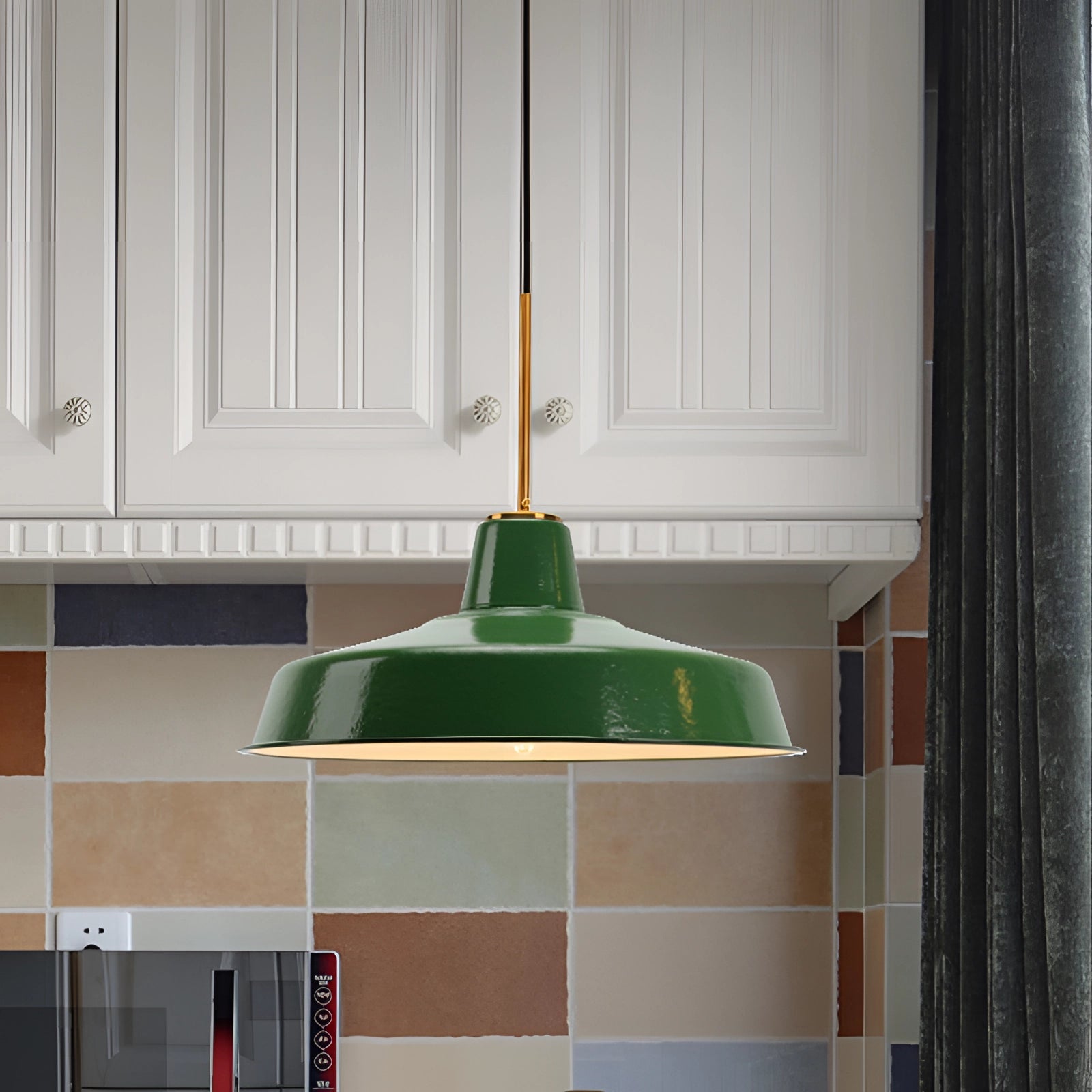 Retro green enamel pendant light with gold trim hanging from a ceiling, featuring a vintage design and classic fixture shape.