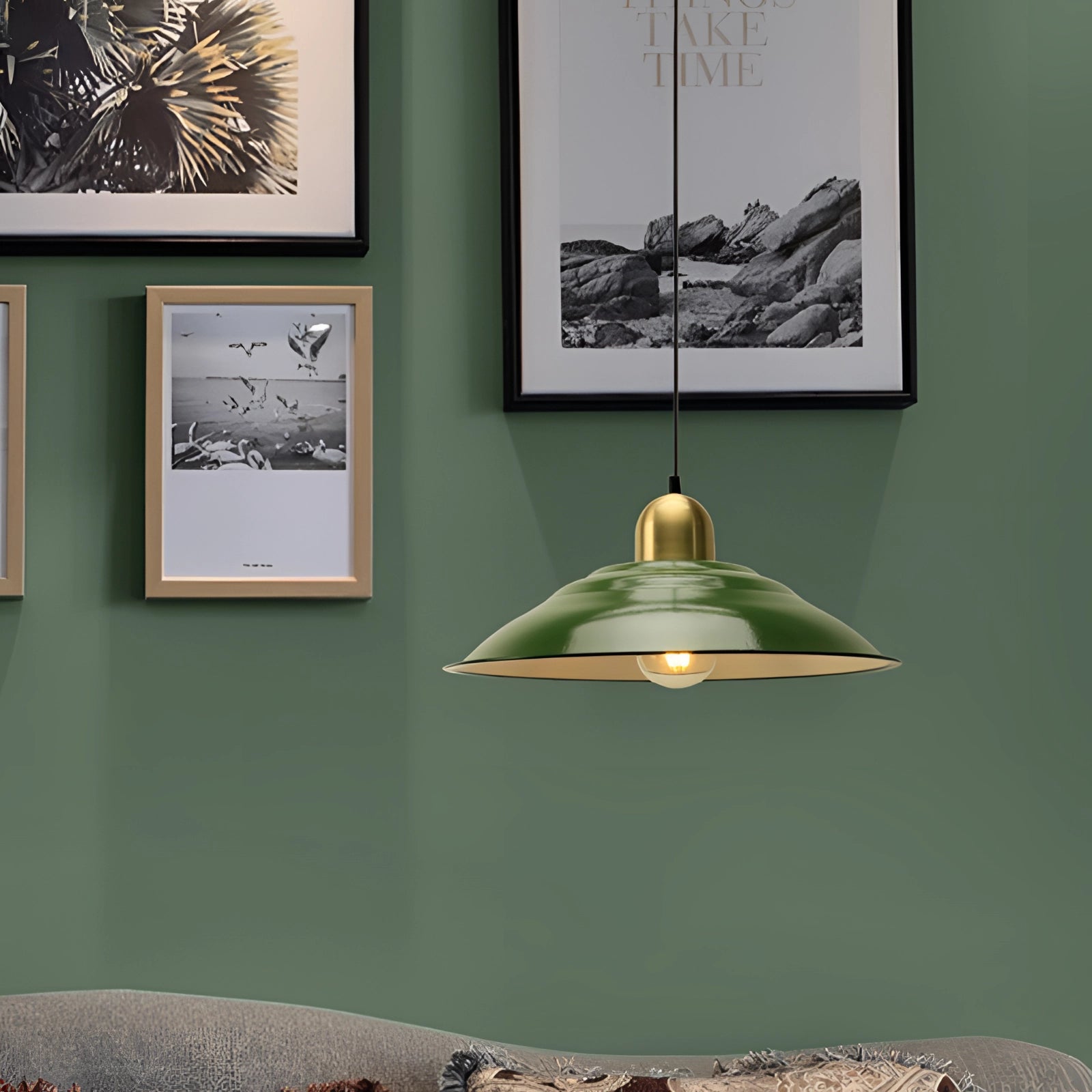 Retro green enamel pendant light with gold trim hanging from the ceiling in a vintage interior setting, with a wooden framed wall art in the background, showcasing an elegant and classic design.