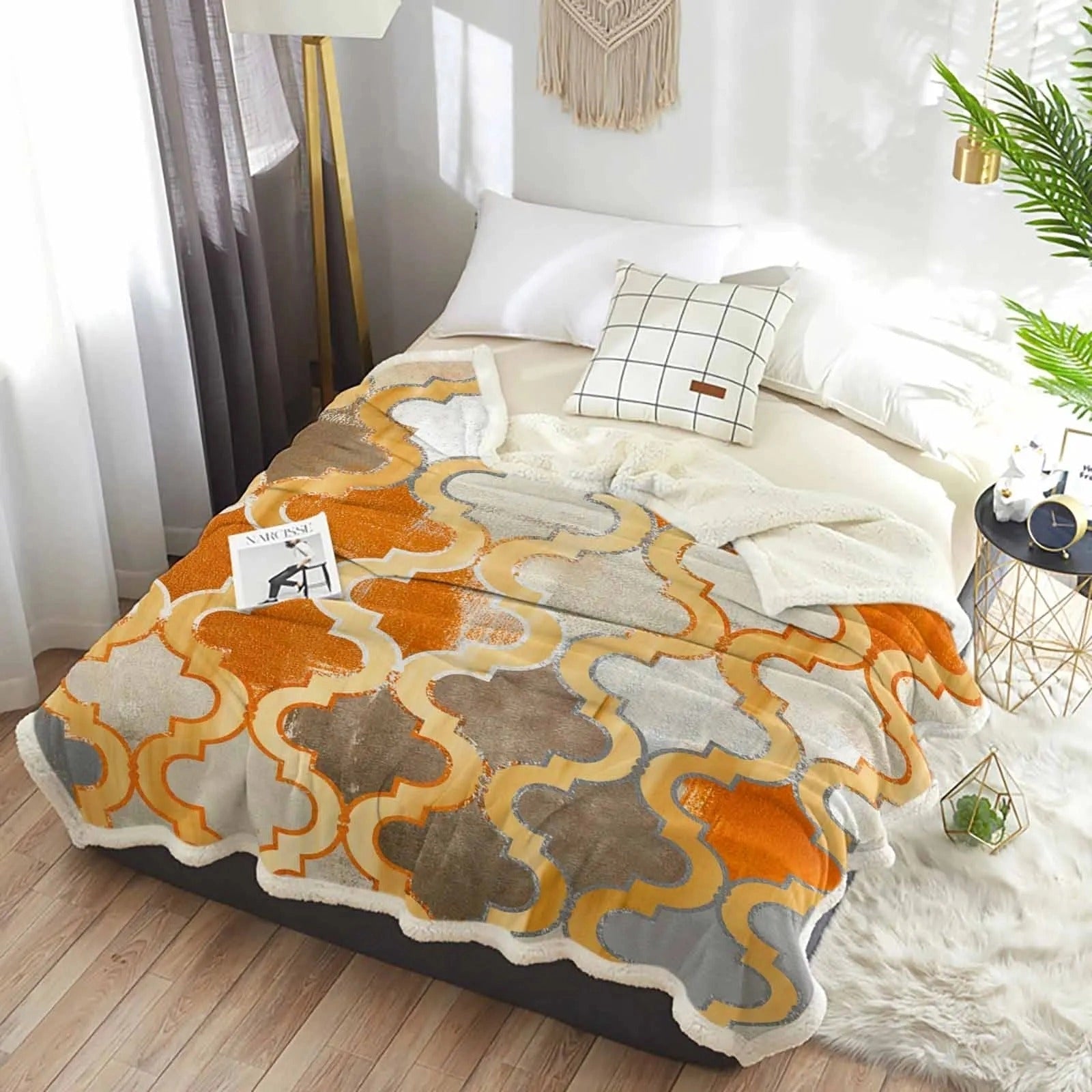 Orange cashmere blanket draped over a wooden table with plants nearby, showcasing retro Moroccan design and cozy interior decor elements.
