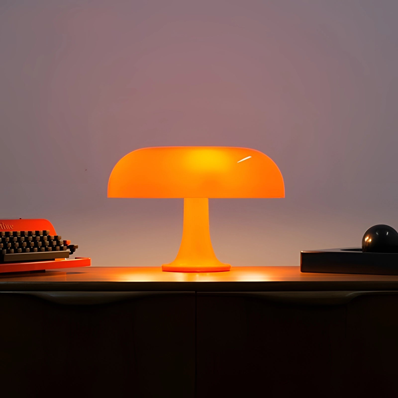 Retro orange mushroom-shaped lamp with a mid-century modern design, featuring a warm amber glow suitable for table placement and artistic lighting decor.
