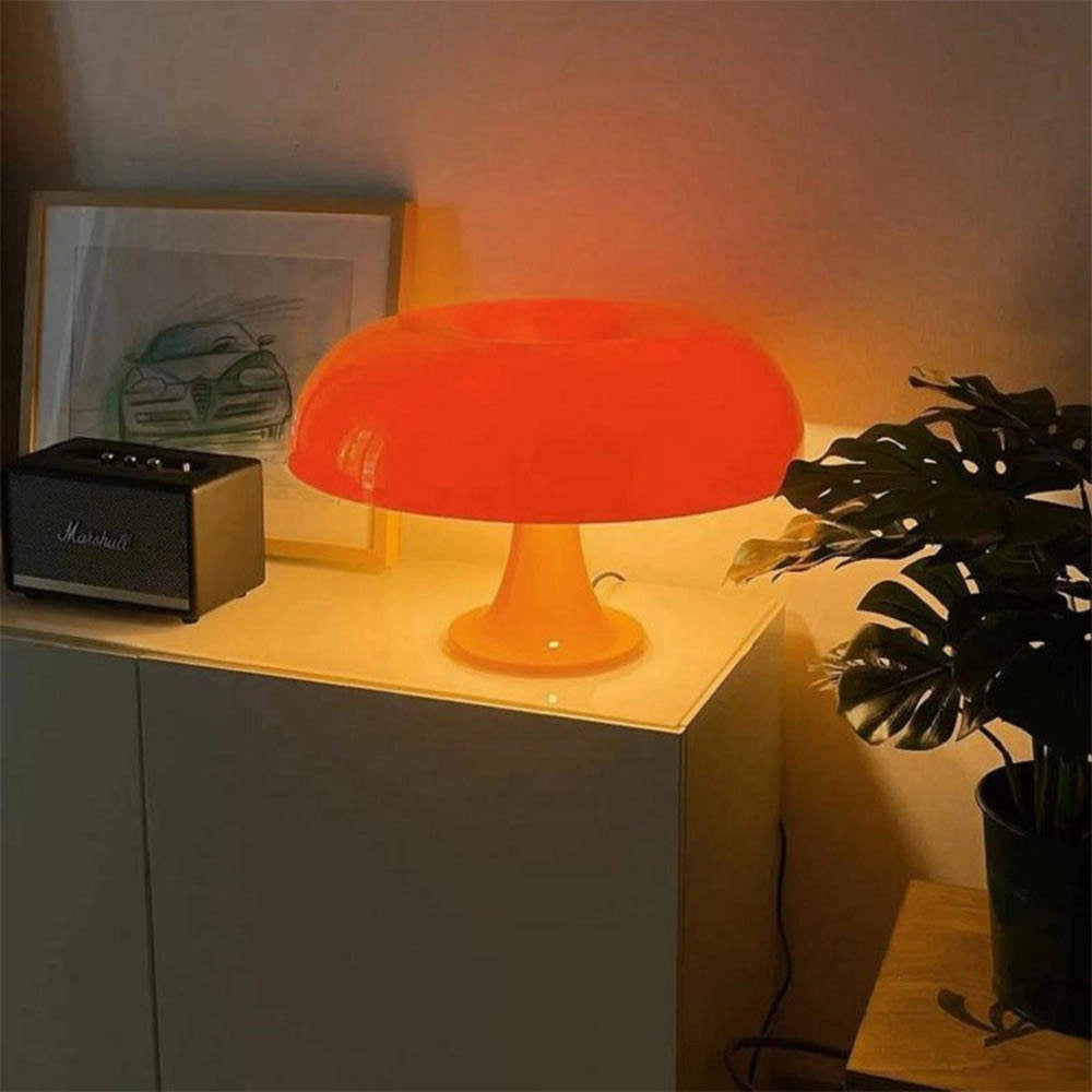 Orange retro mushroom lamp in a mid-century modern interior setting, featuring a sleek design and warm ambient lighting, set against a backdrop of a stylish orange-toned wall with subtle artistic elements and accompanied by a houseplant.