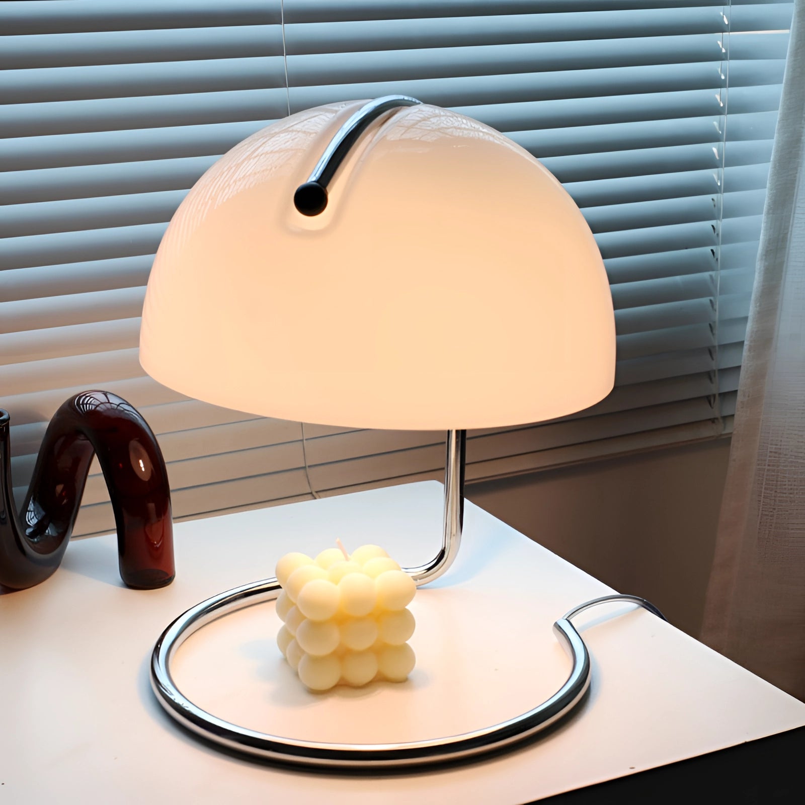 Retro yellow chrome mid-century desk lamp with an elegant design, featuring a white lampshade, displayed on a wooden table in a stylish interior setting.