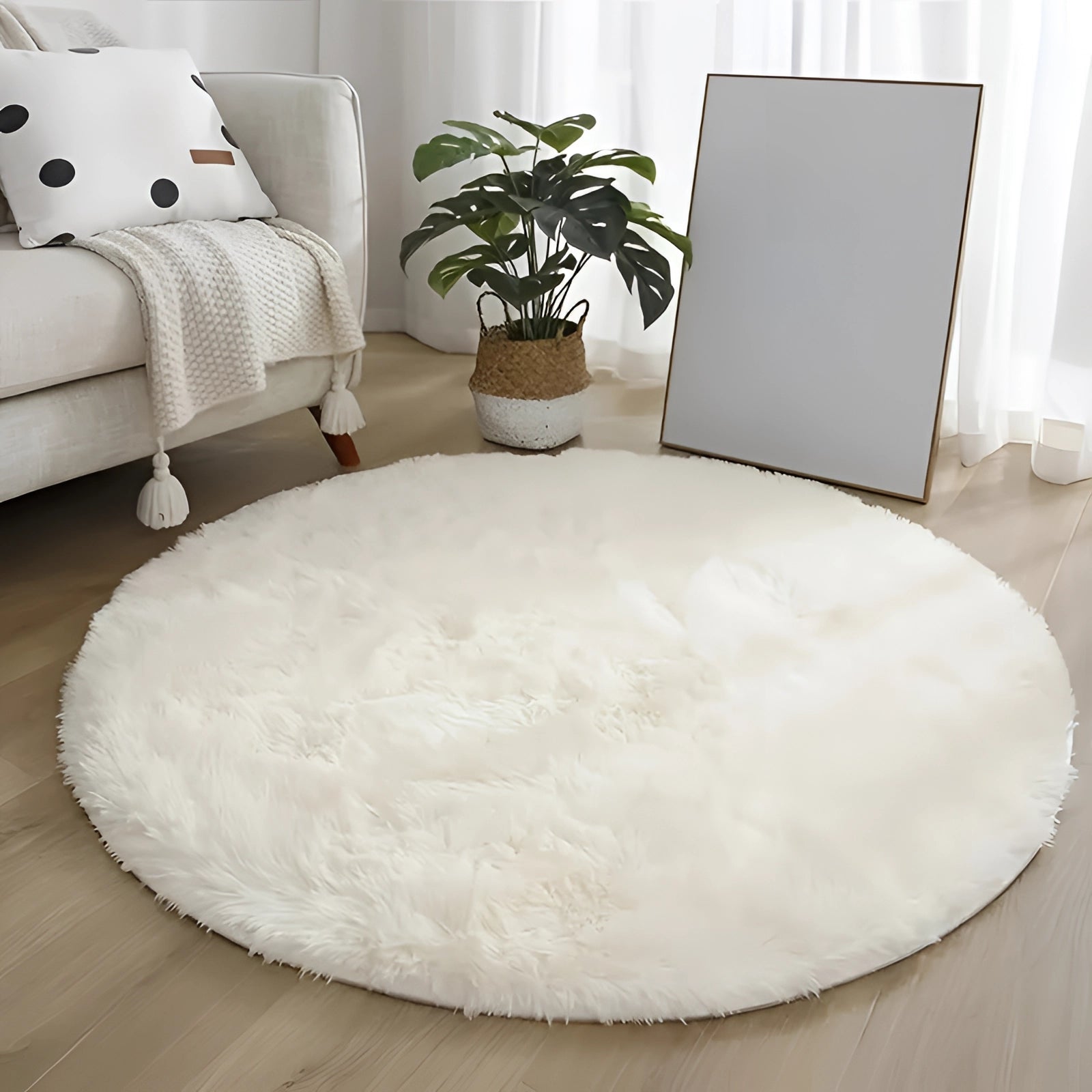 Plush round white faux fur rug on a wooden floor, enhancing a modern minimalist interior design.