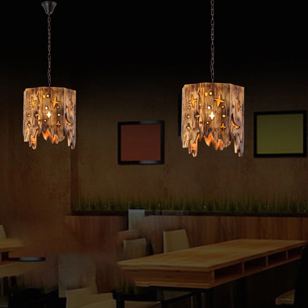 Rustic star cut-out wooden pendant light hanging from the ceiling in a farmhouse-style interior with wooden elements and art on the walls.