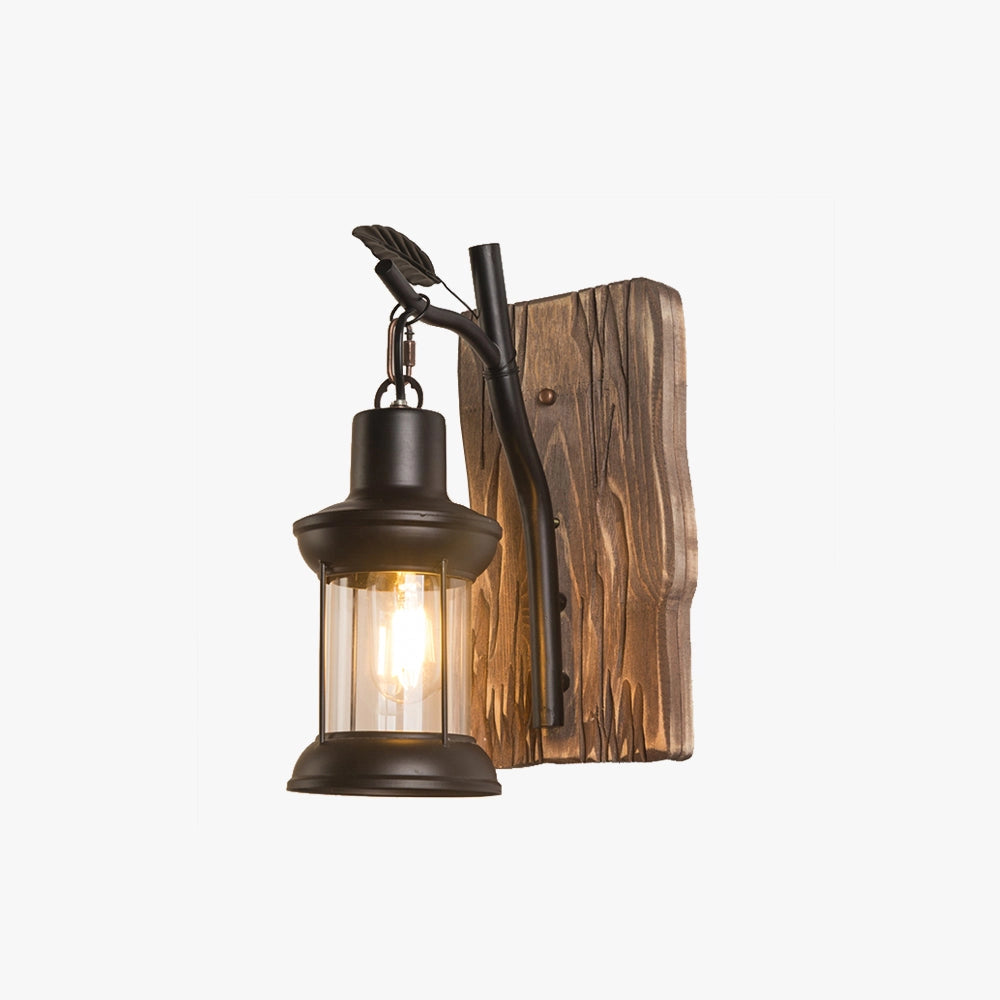 Rustic vintage lantern sconce with a wooden mount, featuring a metal and bronze finish, designed for cabin lighting.