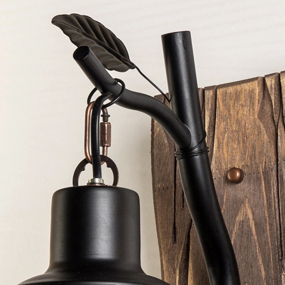 Rustic vintage lantern sconce with a wooden mount, featuring a classic design ideal for cabin lighting, made of metal and wood.