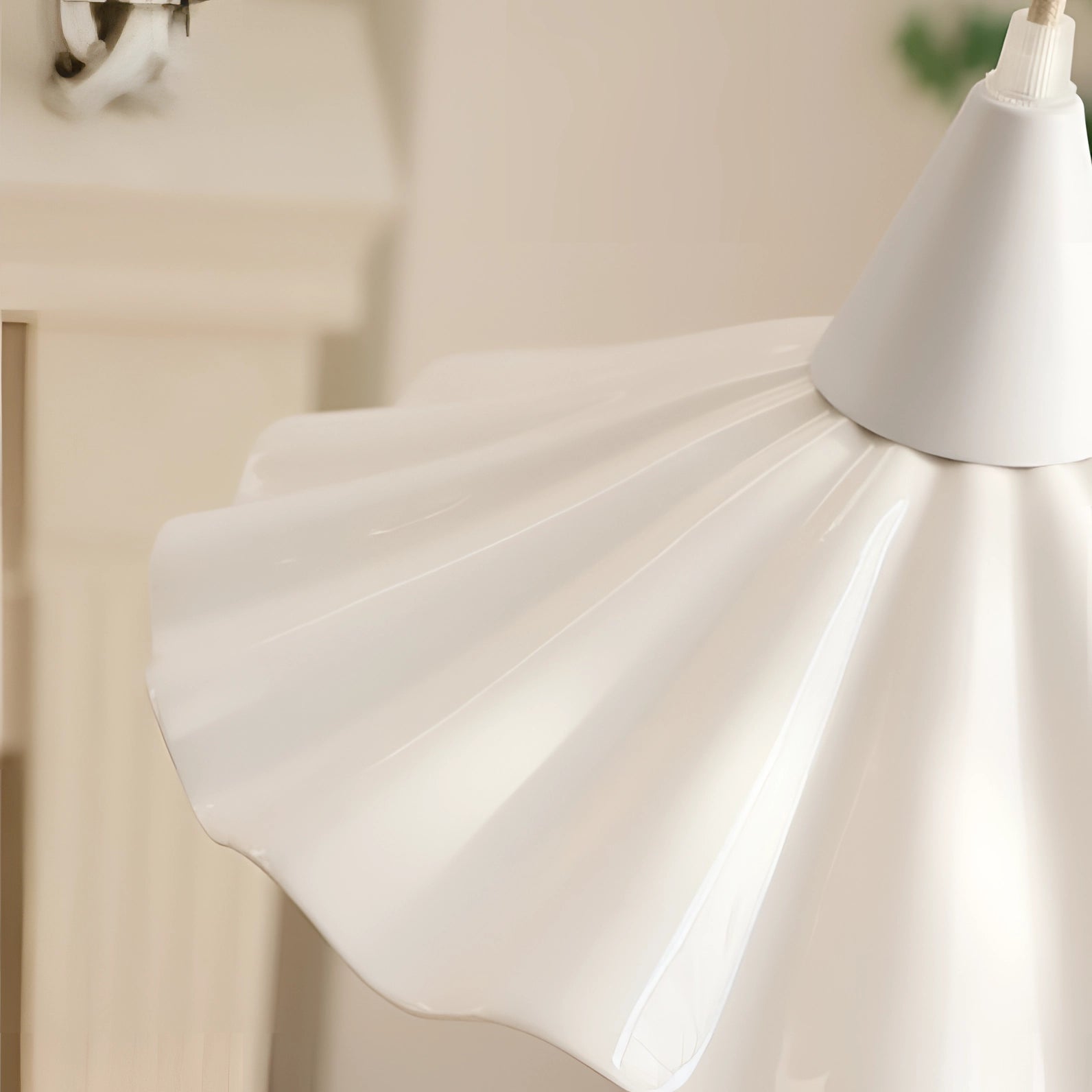 Scallop-edged LED pendant light with a modern design, featuring a white finish, hanging from a ceiling in a stylish interior setting.
