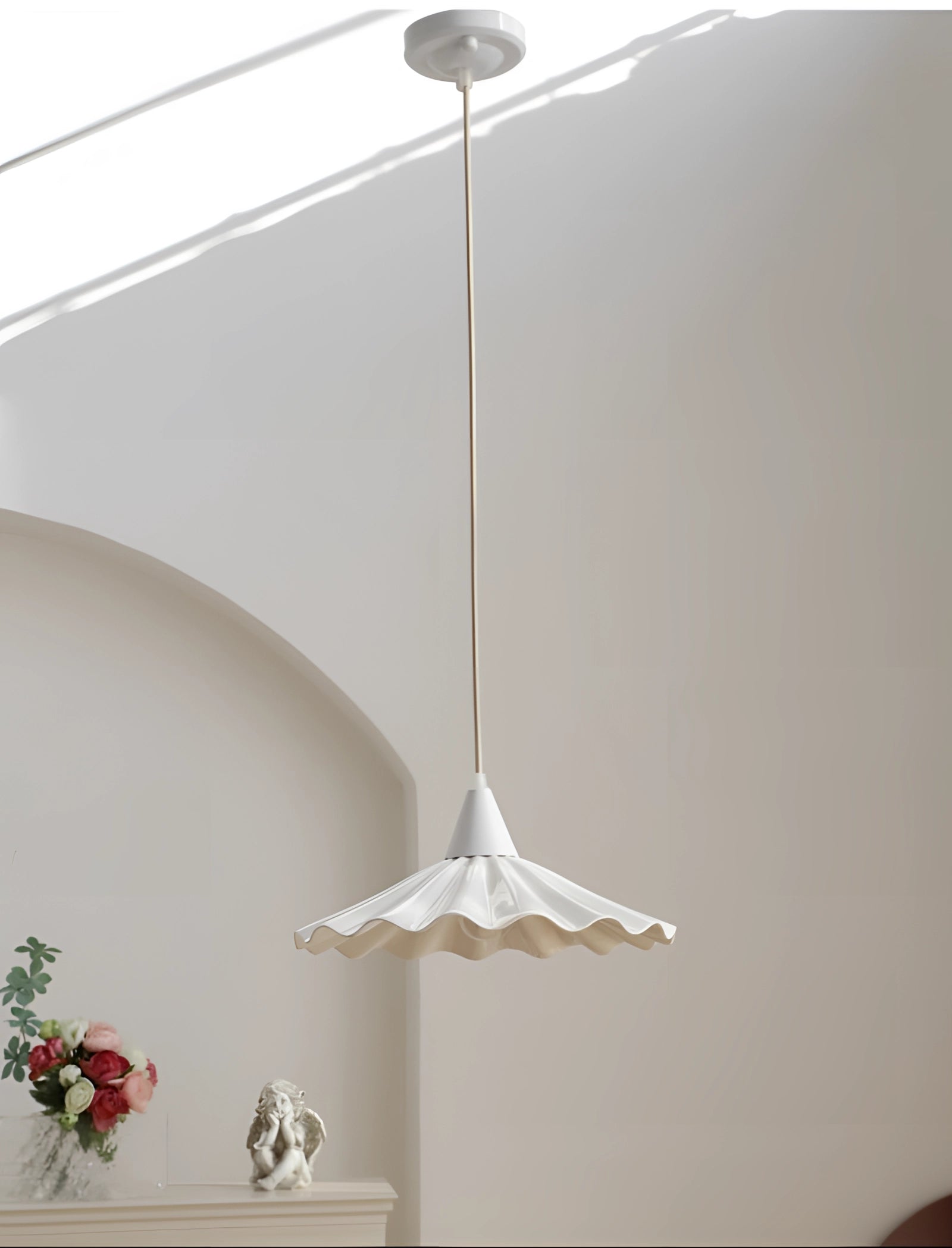 Scallop-Edged LED Pendant Light featuring a modern design, hanging from the ceiling with a decorative scallop-edged shade, illuminating a room with a neutral wall and wooden elements.